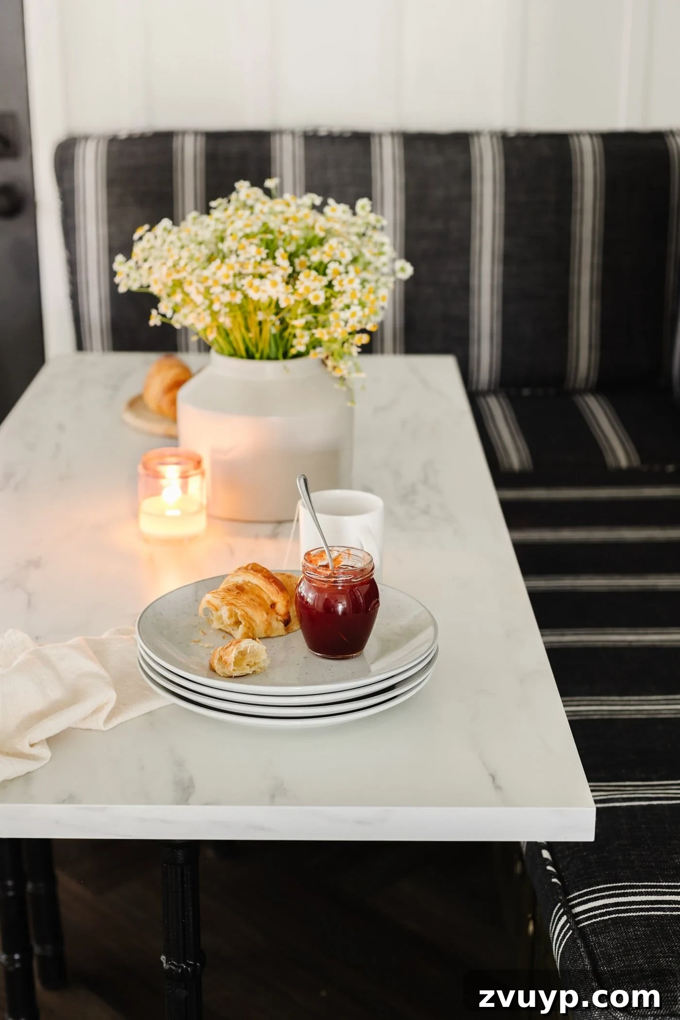 Bonjour Mornings: Your Cozy Parisian Bistro Nook 12 marble dining table top with plates stacked and vase of daisy flowers