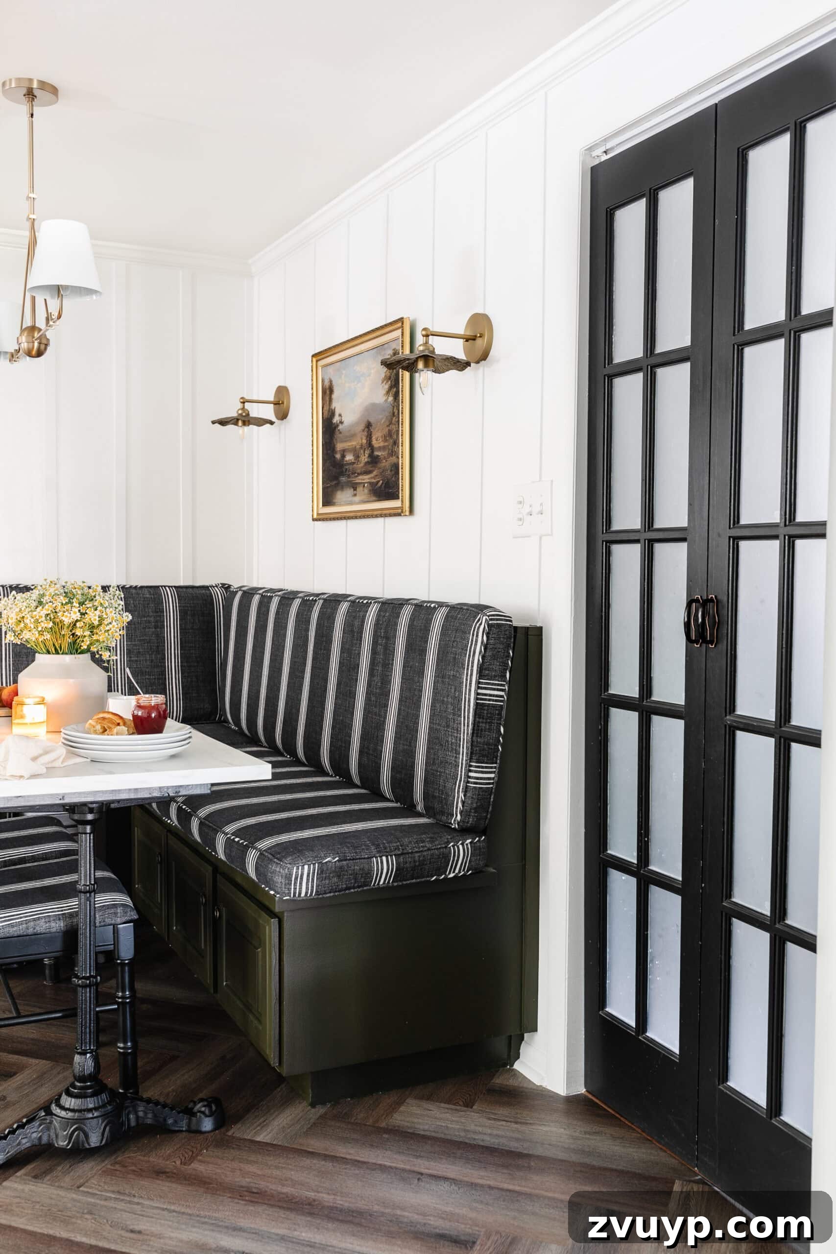 Bonjour Mornings: Your Cozy Parisian Bistro Nook 5 breakfast nook with booth, batten wall, vintage oil painting art, bifold French door, and Parisian bistro table