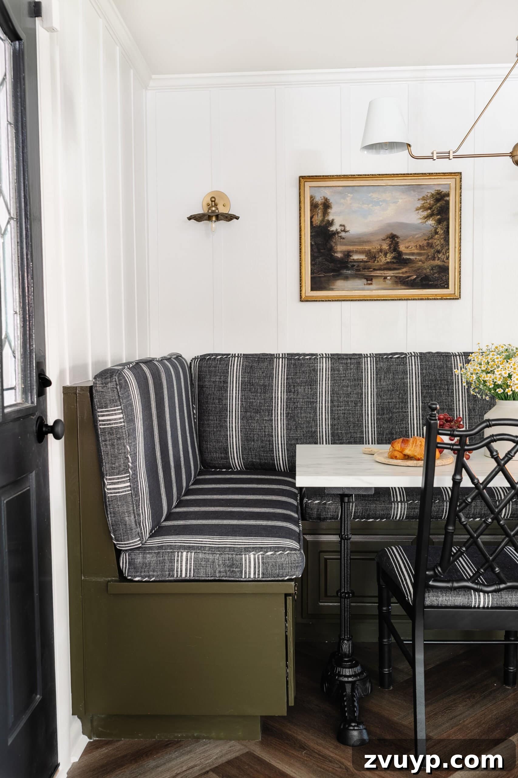 Bonjour Mornings: Your Cozy Parisian Bistro Nook 8 striped charcoal cushions on a banquette bench painted olive green with white batten walls and an antique landscape oil painting