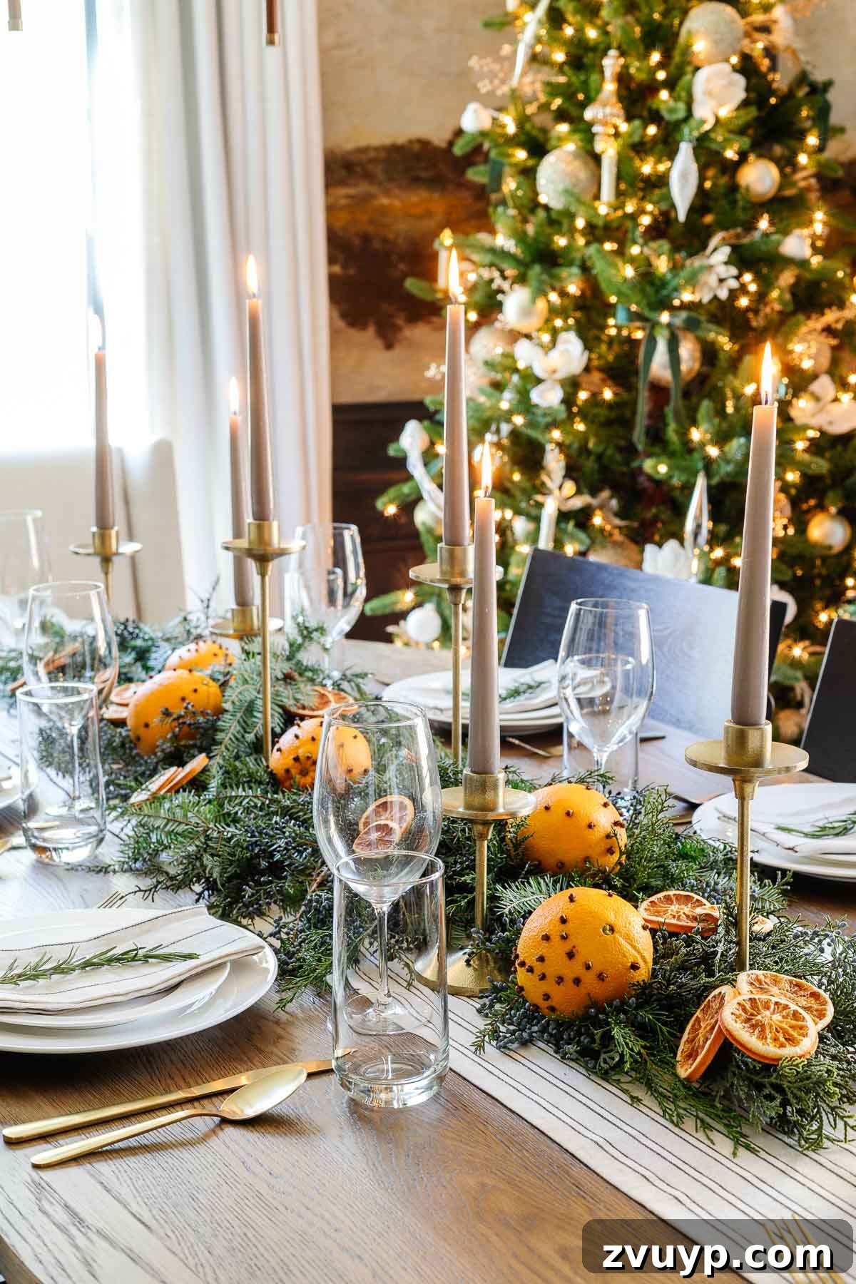 Your Go-To Guide for Flawless Table Settings, Every Time 12 a festive Christmas dining table centerpiece featuring fresh leaves, dried orange slices, and elegant candlesticks, creating a warm holiday ambiance