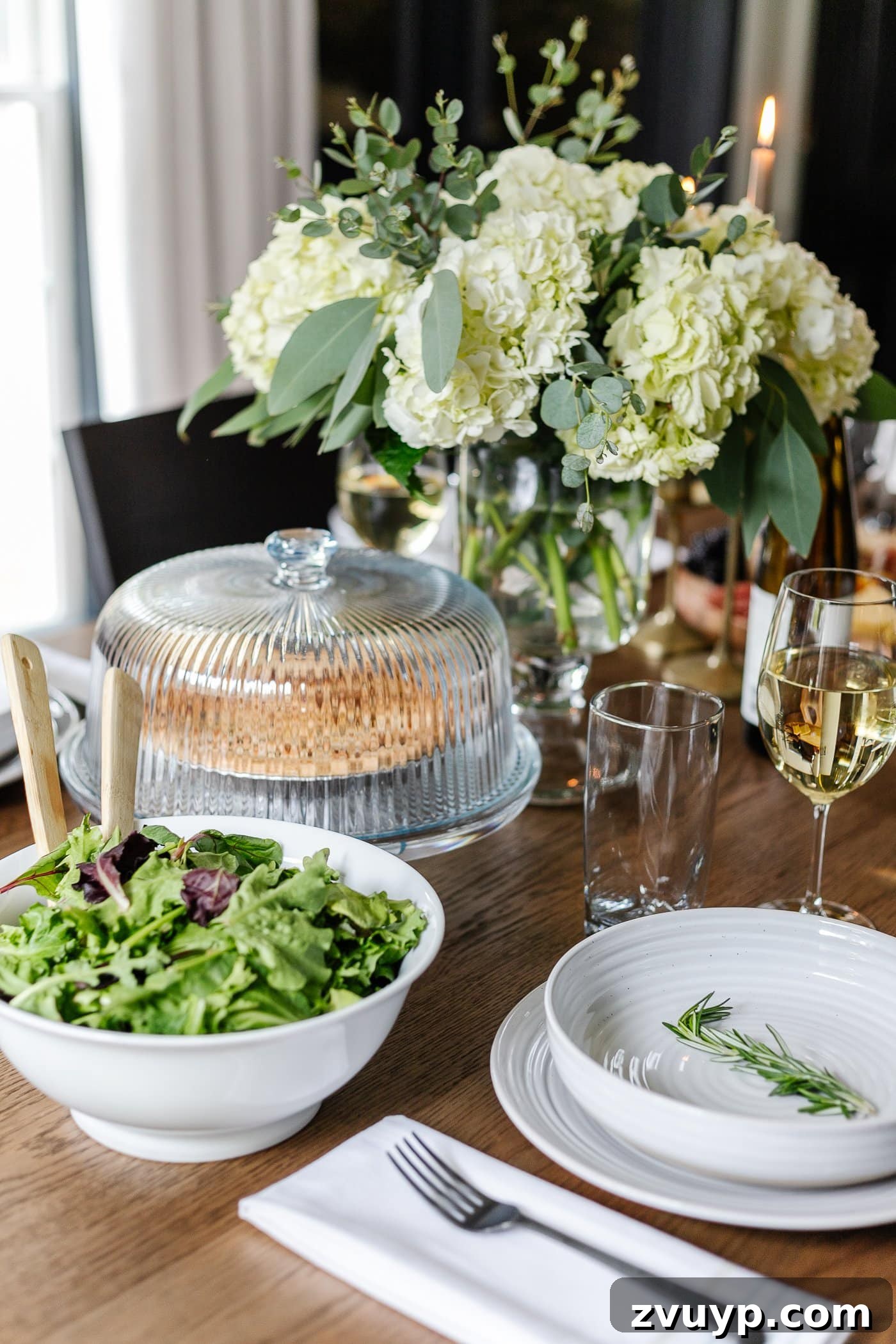 Your Go-To Guide for Flawless Table Settings, Every Time 14 a dinner table displaying versatile serving dishes, including a practical cake dome, a fresh salad bowl, and a graceful vase of flowers, creating an inviting spread