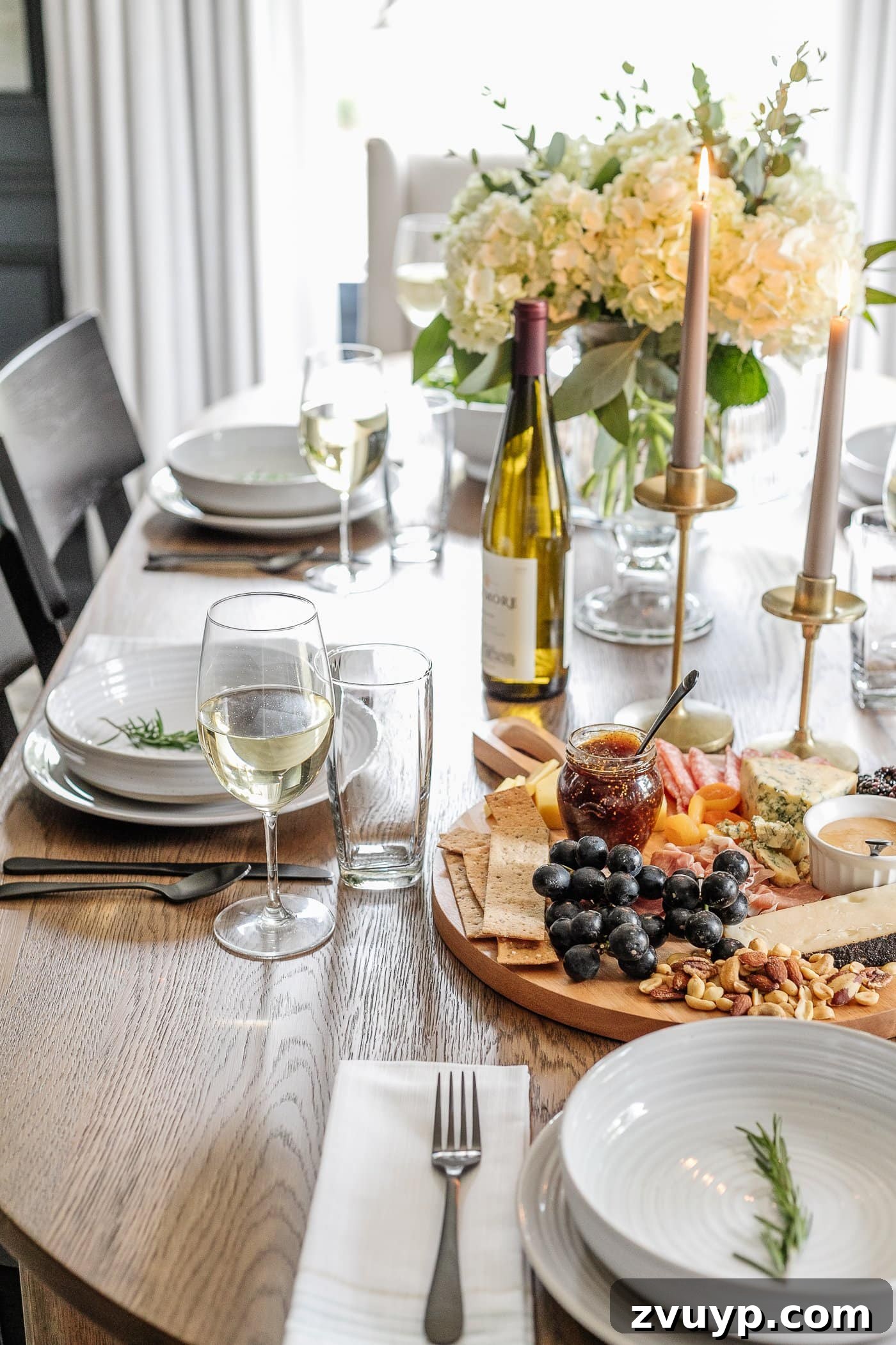 Your Go-To Guide for Flawless Table Settings, Every Time 17 an elegantly set dinner table featuring simple place settings, wine glasses, a lavish charcuterie board, flickering candlesticks, and a delicate vase of flowers, creating a sophisticated dining experience