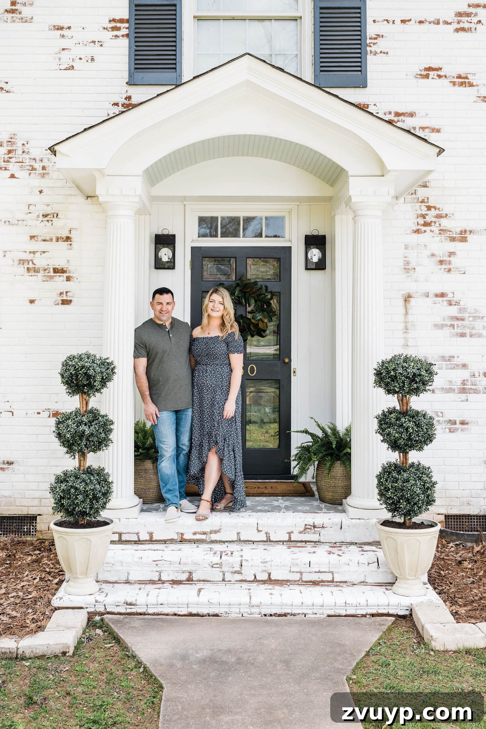 Our Home's Incredible 5-Year Transformation Tour 2 limewashed brick front porch stoop on a colonial house with boxwood topiaries, a welcoming entrance