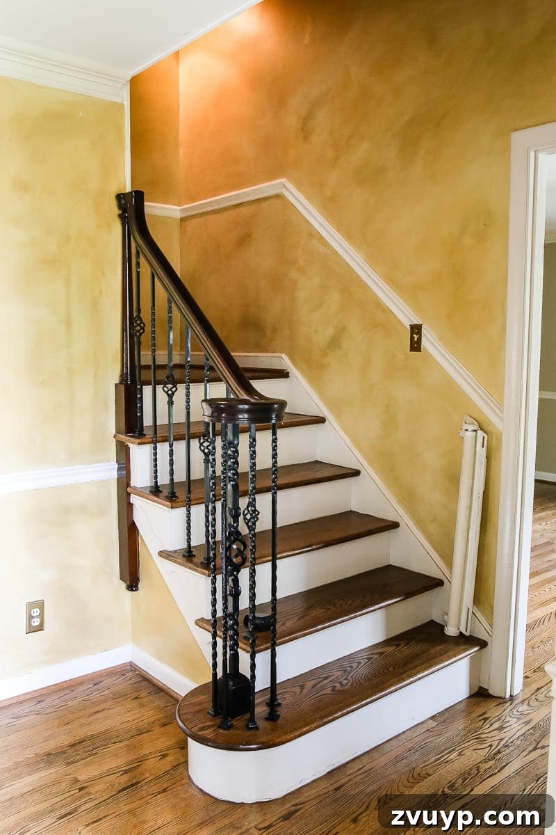 Our Home's Incredible 5-Year Transformation Tour 9 before foyer entryway and staircase with dated yellow walls and dark hardwood floors