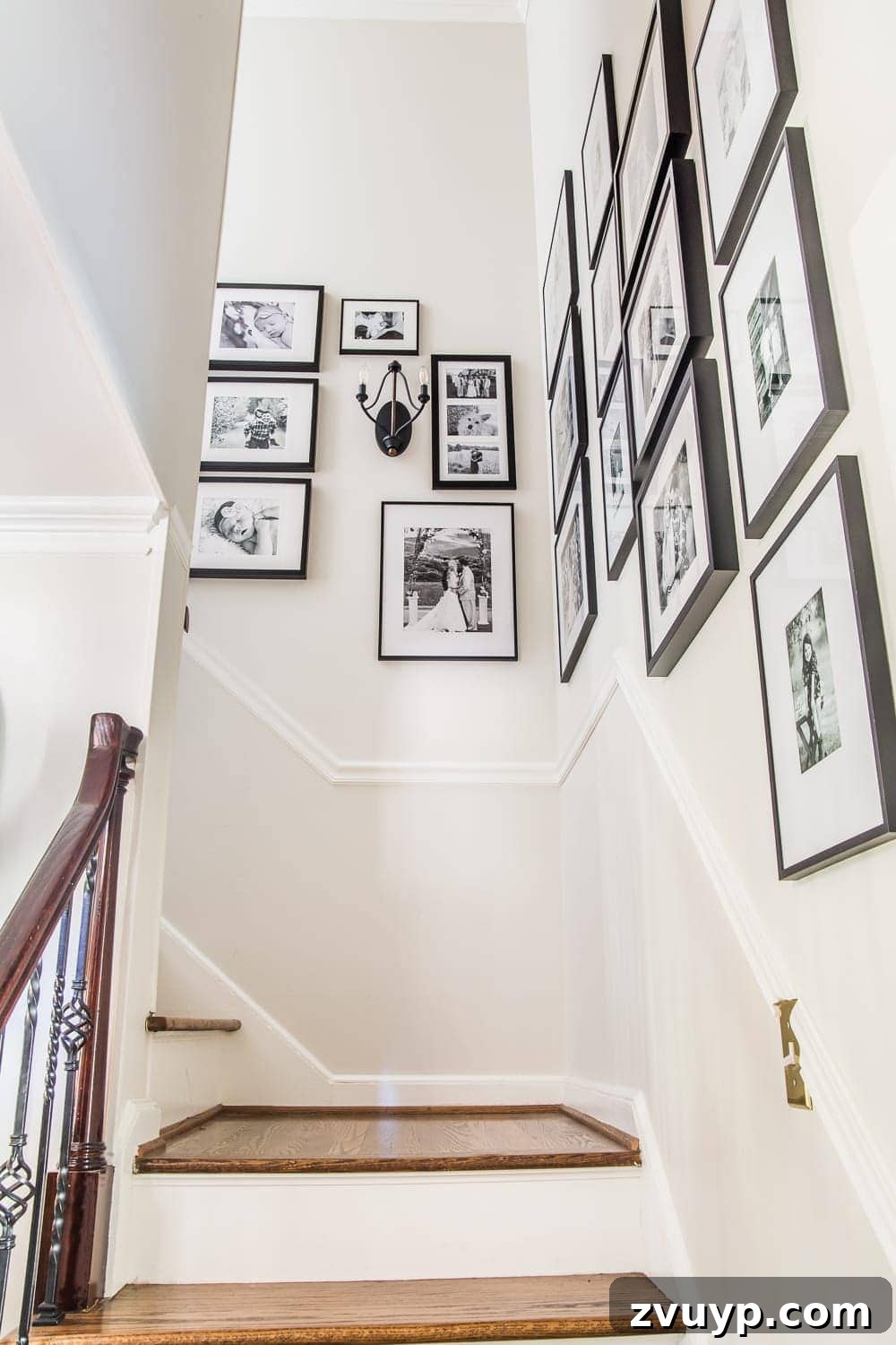 Our Home's Incredible 5-Year Transformation Tour 11 elegant black and white family gallery wall adorning the stairs, creating a personalized and stylish display
