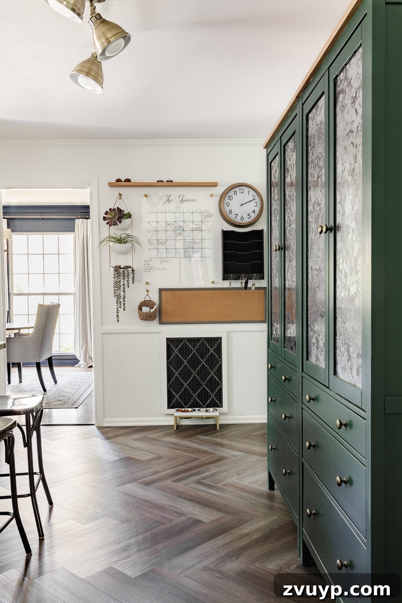 Our Home's Incredible 5-Year Transformation Tour 23 functional family command center featuring a calendar, memo board, and mail drop zone, perfectly situated beside convenient IKEA pantry cabinets, promoting organization and efficiency