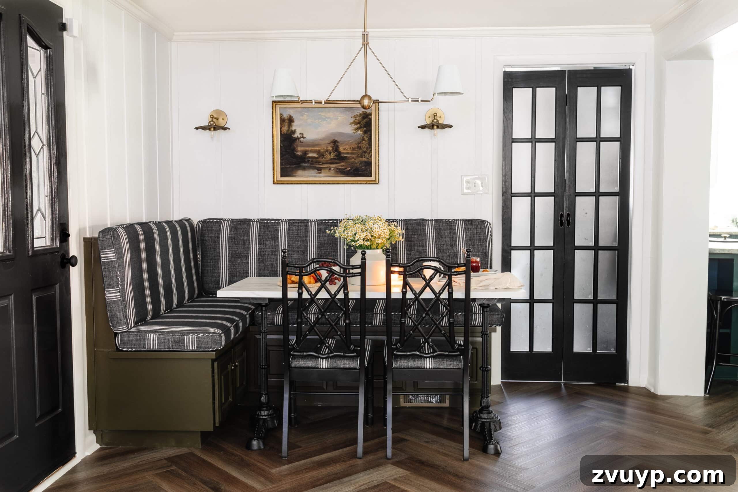 Our Home's Incredible 5-Year Transformation Tour 25 charming cottagecore breakfast nook, featuring a built-in banquette, an elegant shaded chandelier, a practical bifold French door, stylish herringbone flooring, and a chic marble bistro table, creating a cozy and inviting dining space
