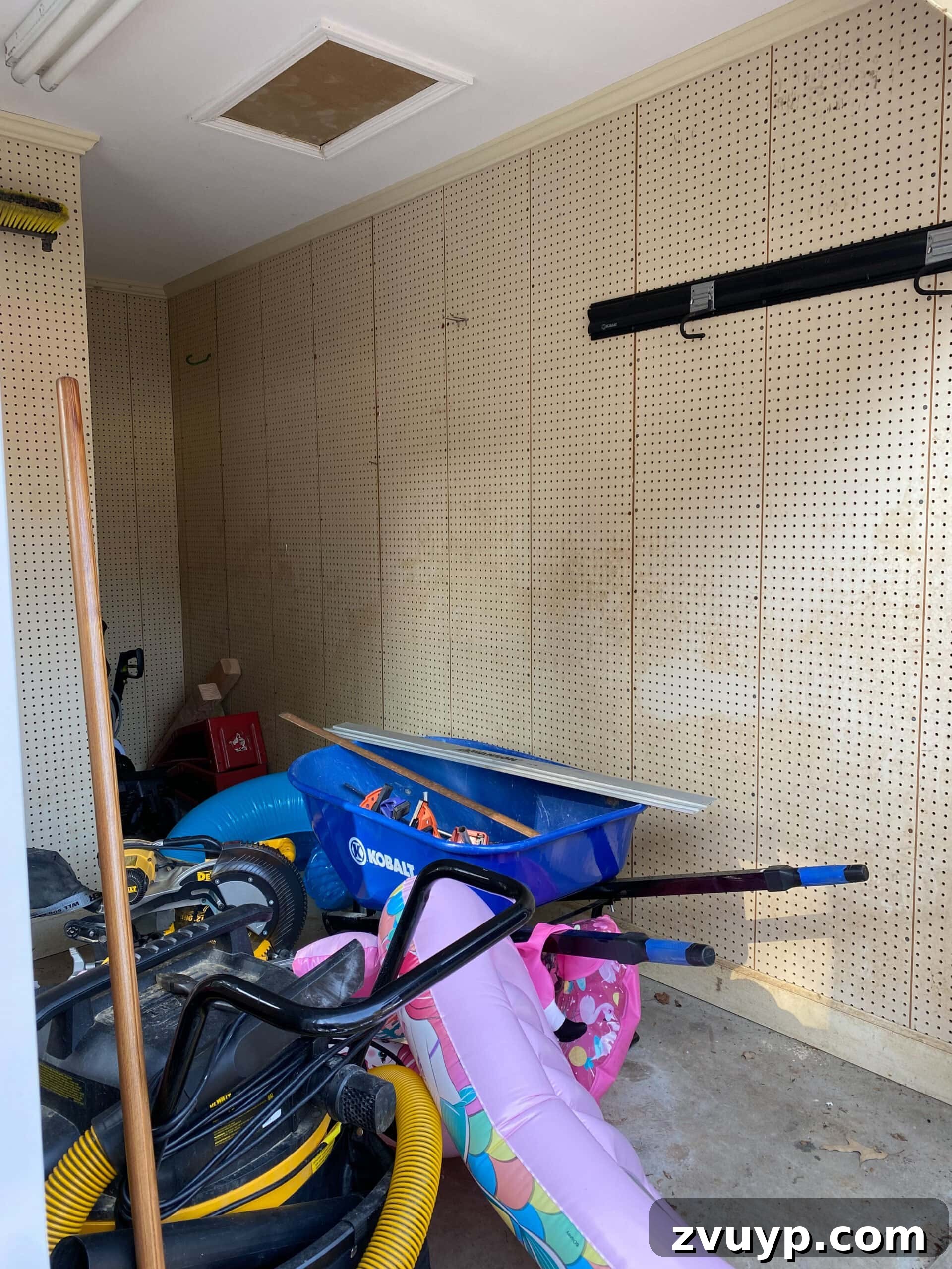 Our Home's Incredible 5-Year Transformation Tour 75 before shed interior with plain pegboard walls, used for disorganized storage