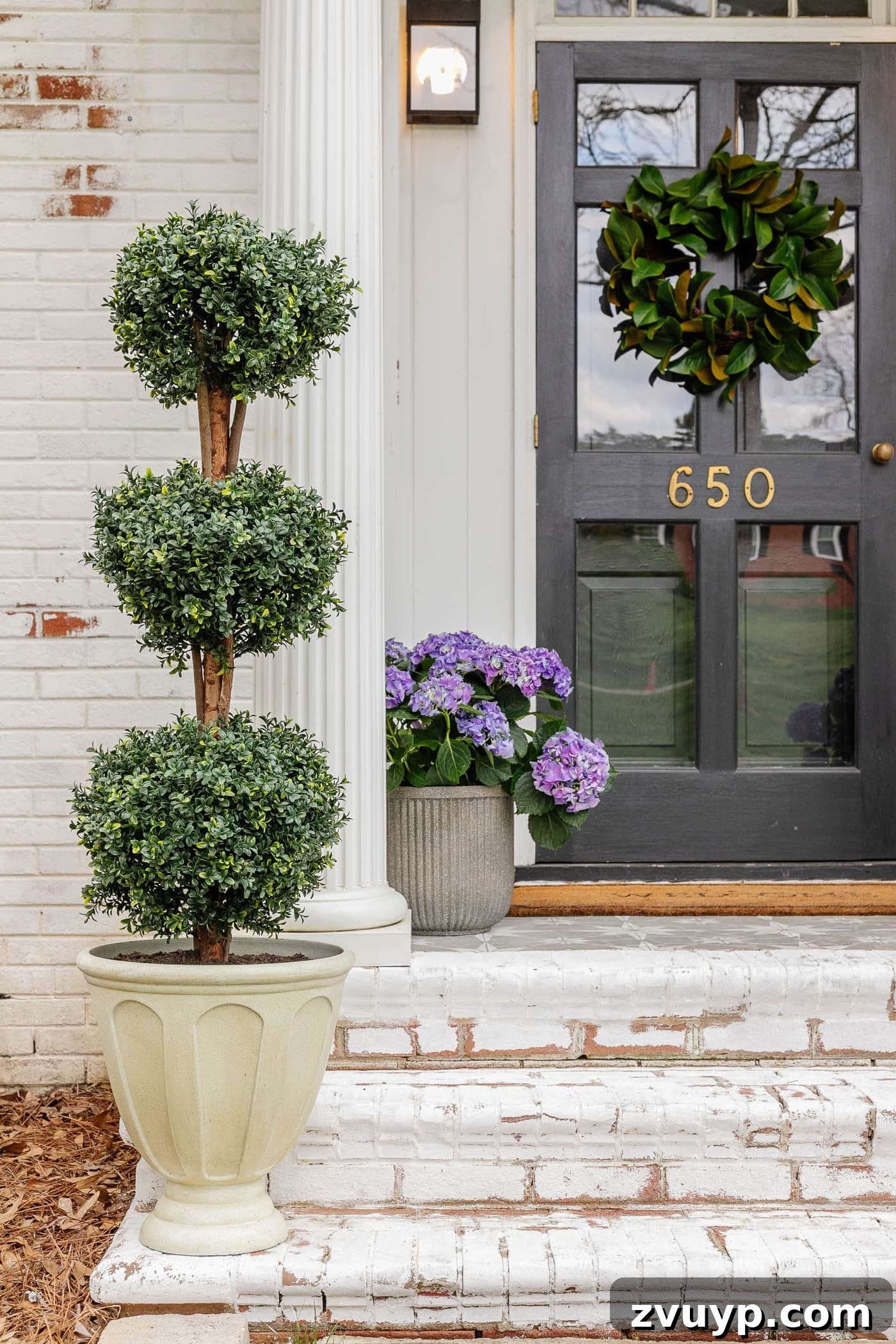 urn planter filled with dirt to make an artificial tree topiary look more realistic