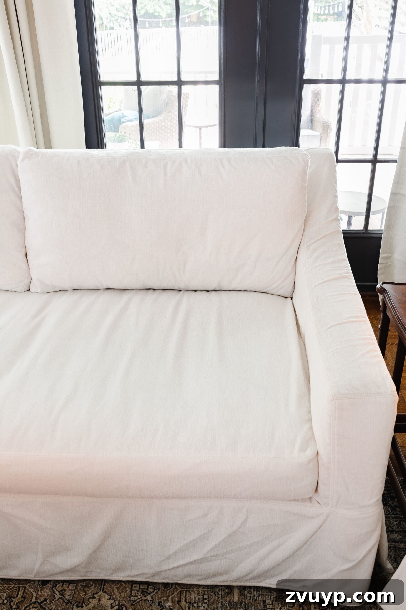 Revive Your Fabric Furniture The Ultimate Upholstery Deep Clean 14 A beautifully clean white slipcovered couch in a bright and airy living room, sparkling after cleaning.