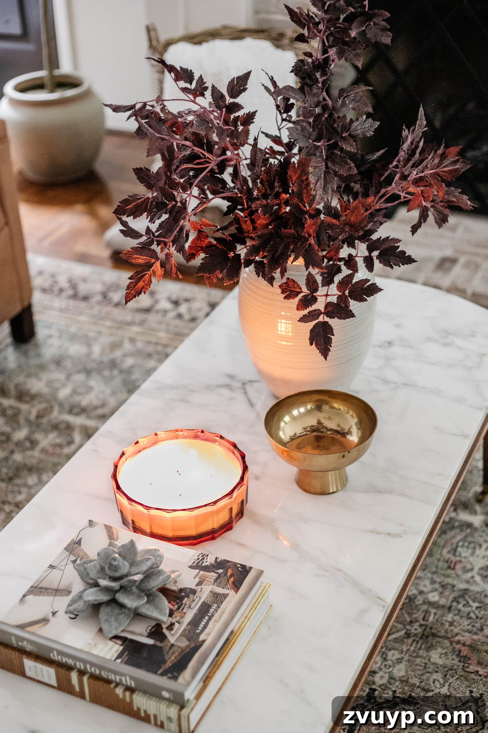fall coffee table decor with vase of fall stems, candle, bowl, and books