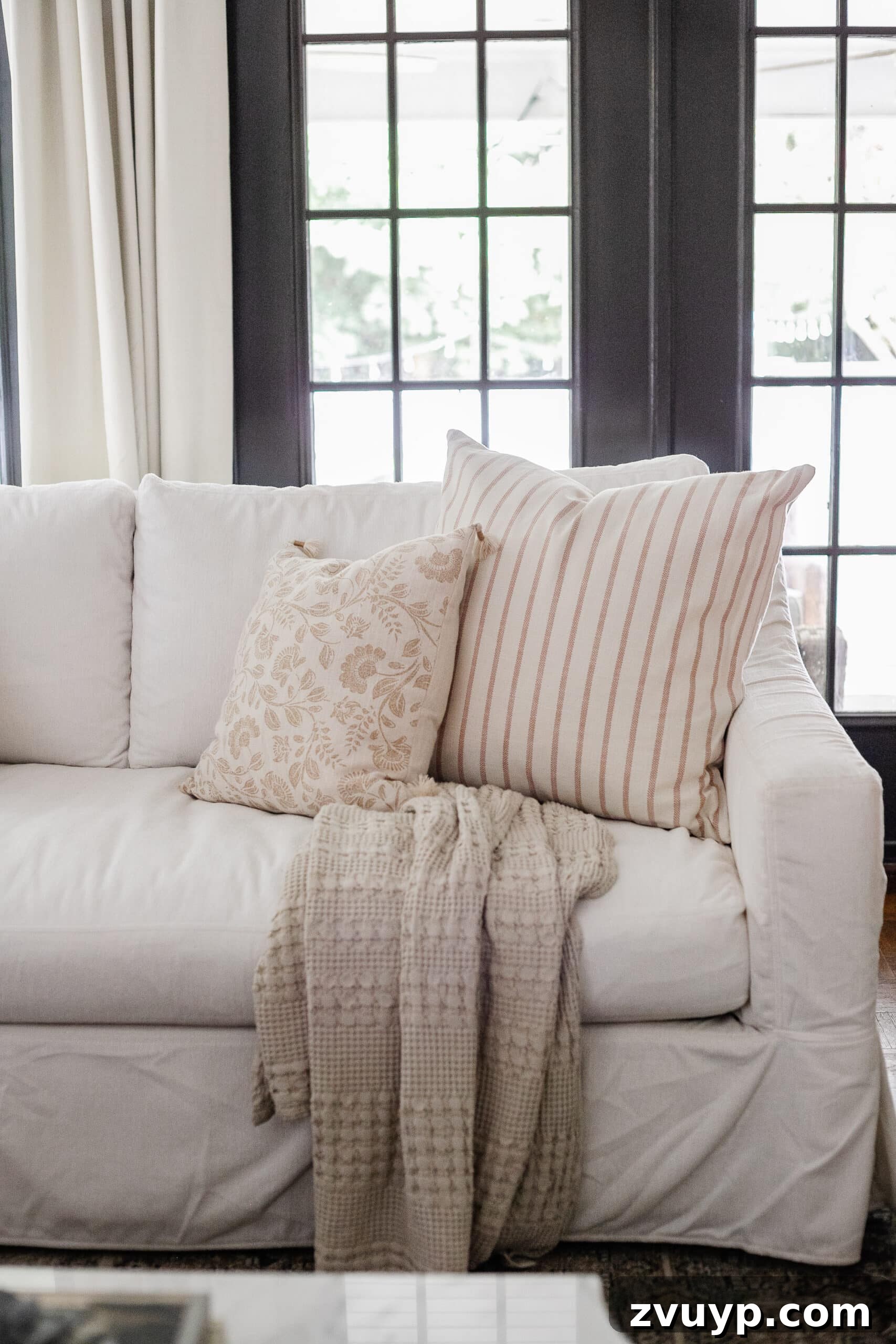 neutral fall pillows on a white couch in a living room decorated for fall