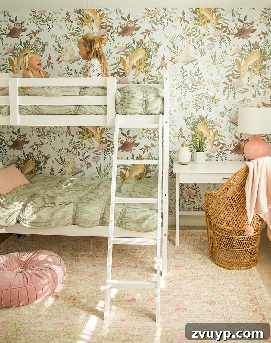 Smart Bunk Beds to Maximize Small Bedrooms 12 Girls' shared bedroom featuring stunning woodland wallpaper as a backdrop, creating a captivating focal point for the bunk bed in a small room.