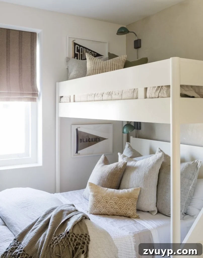 Smart Bunk Beds to Maximize Small Bedrooms 16 Coastal clean and simple twin-over-full bunk bed showcasing luxurious bedding with multiple pillows and layers for ultimate comfort and style.