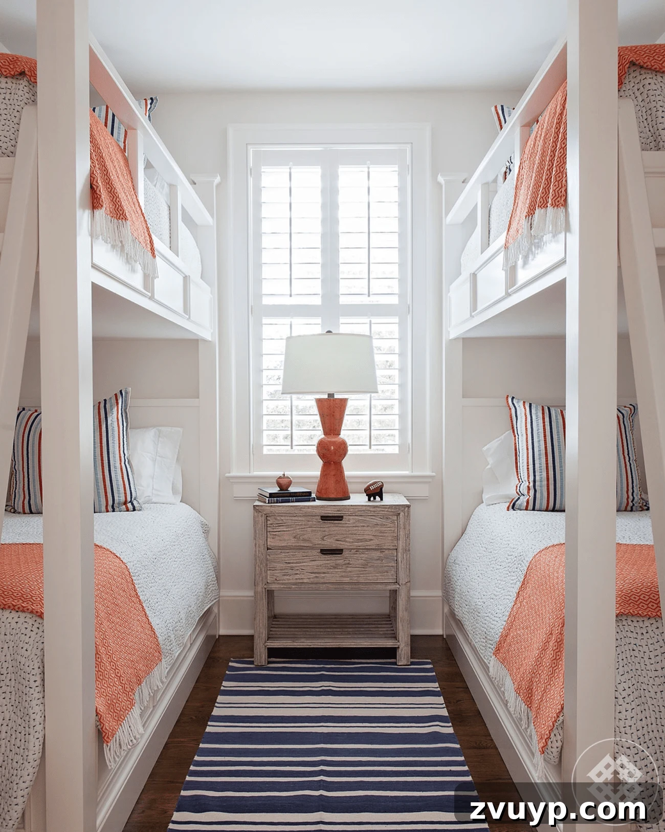Smart Bunk Beds to Maximize Small Bedrooms 10 Small shared bedroom for four people with two bunk beds, featuring matching bedding and symmetrical decor for a harmonious and organized look.