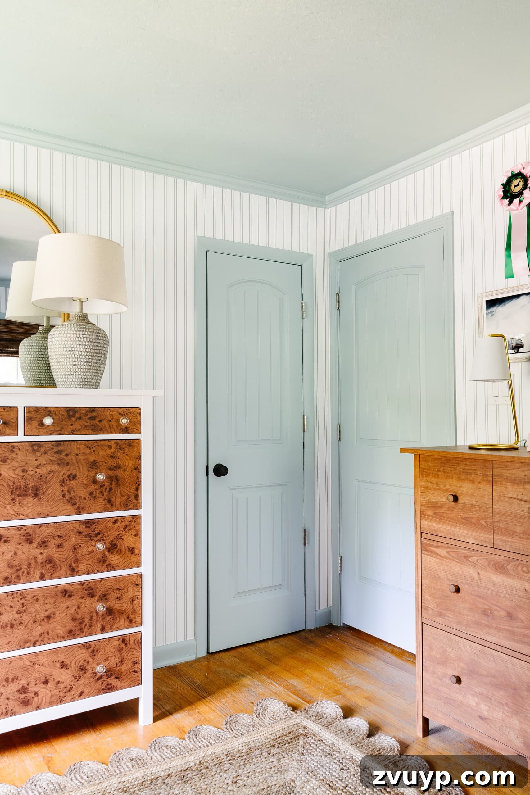 Ultimate Triple Bunk Beach Pad for Teens 6 blue doors, trim, and ceiling with striped wallpaper and wooden dressers in shared teenage beach themed bedroom