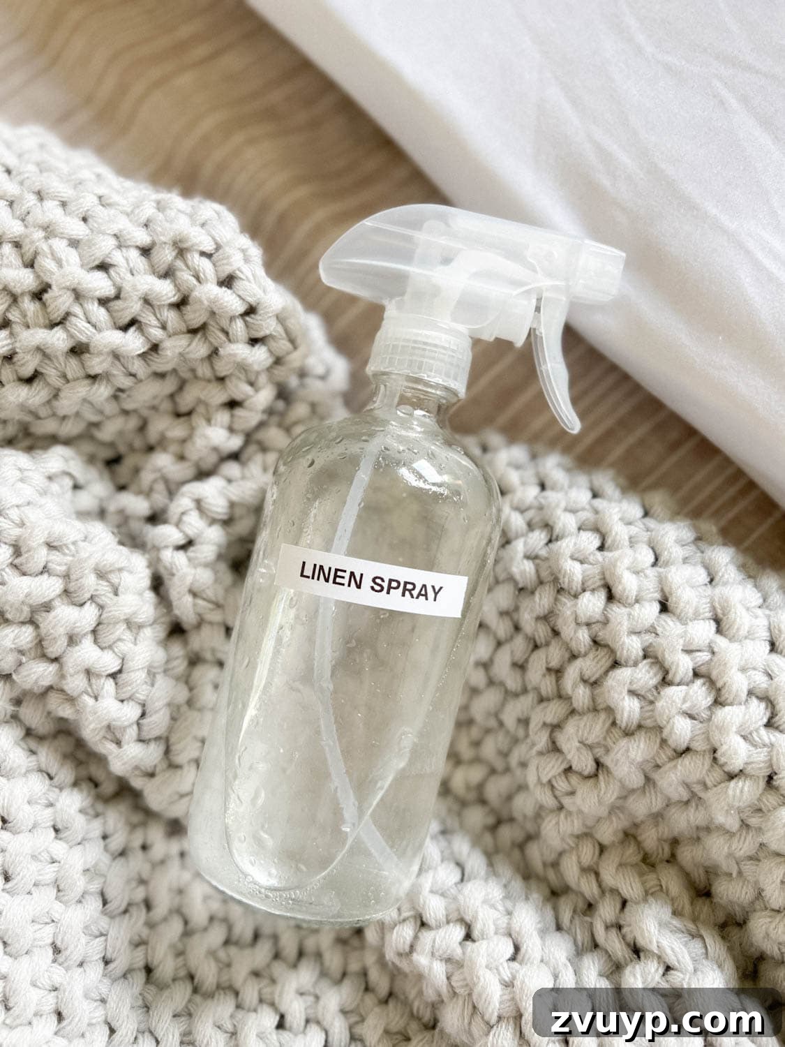 16 Natural Secrets for an Exquisitely Scented Home 11 DIY linen spray in a glass spray bottle on bedding