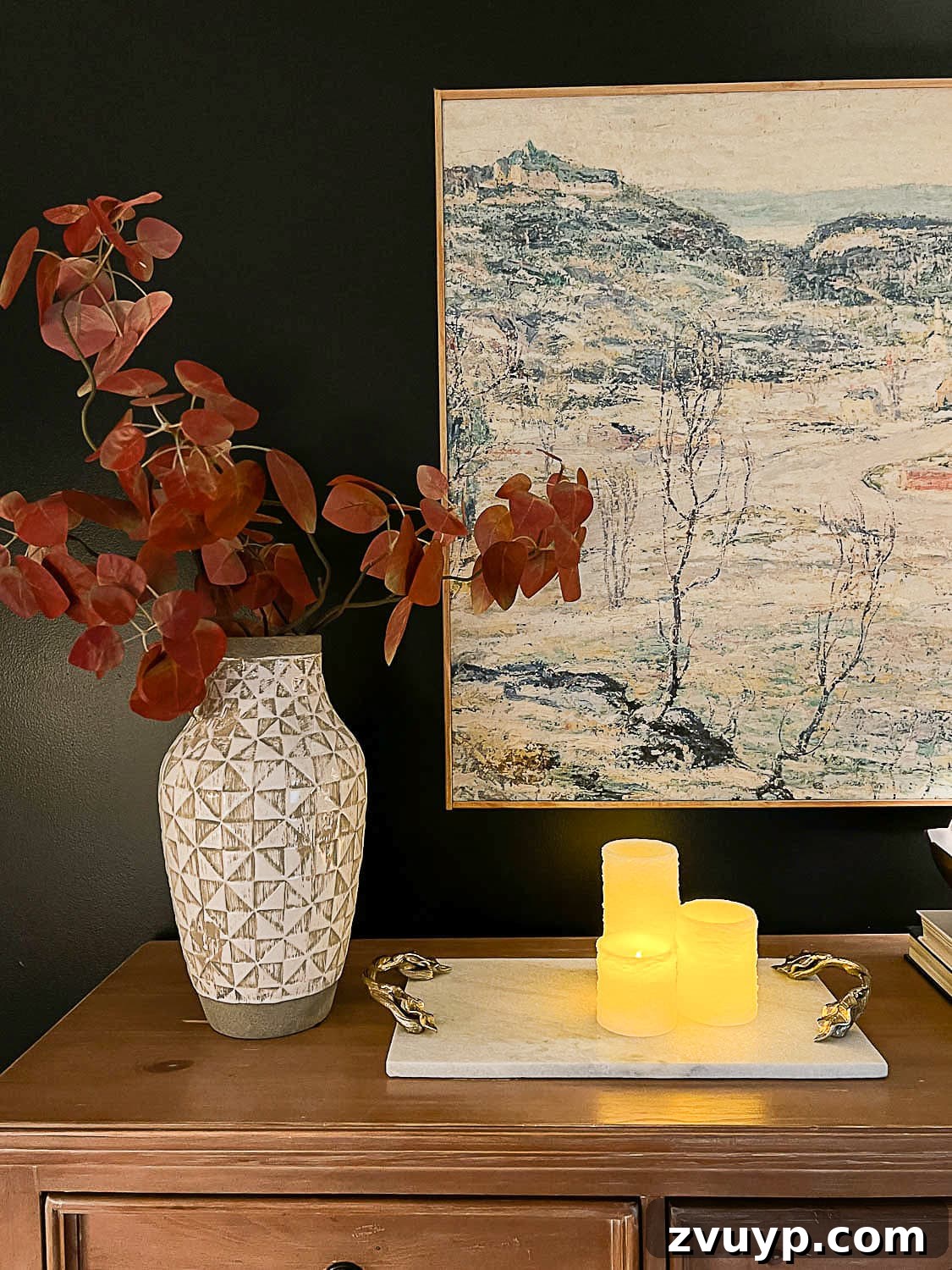 Sweet Dreams on a Budget: 10 Cozy Bedroom Tips for Ultimate Rest 10 A beautifully arranged dresser top featuring realistic flameless candles, an elegant marble tray, a vase filled with vibrant fall branches, and striking large wall art, all contributing to a sophisticated bedroom aesthetic.