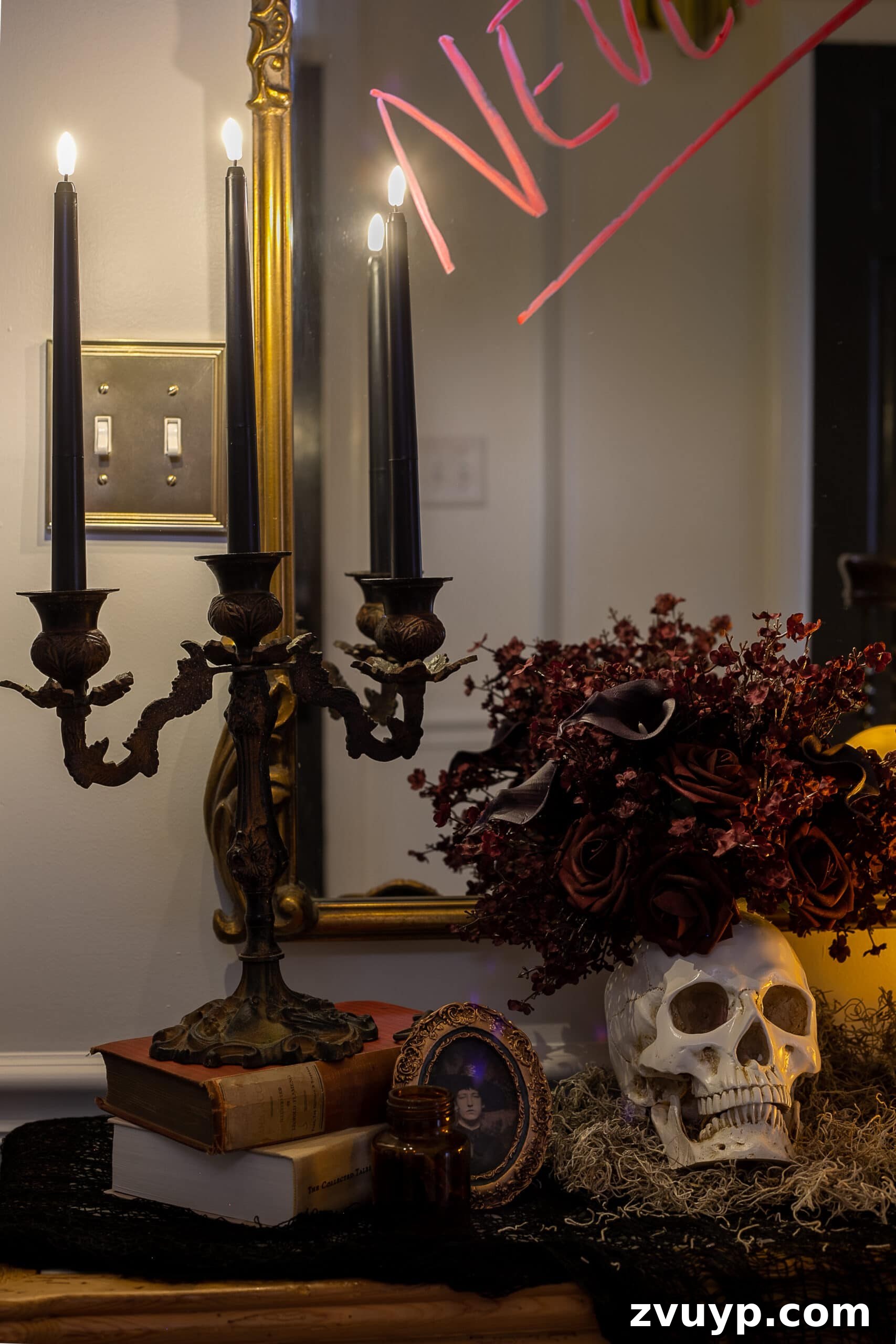 candelabra with flameless candles, vintage picture frame, and skull vase