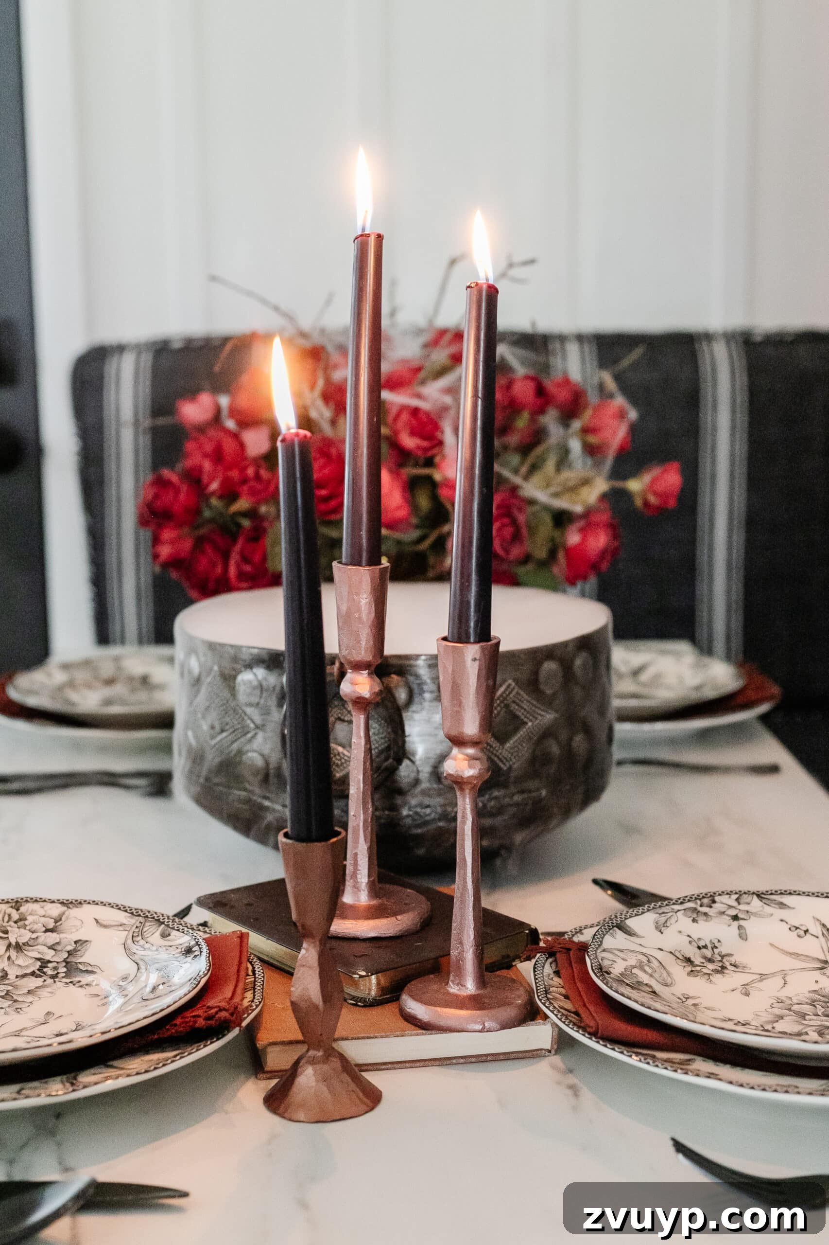 Killer Tablescapes for Your Halloween Murder Mystery 12 hammered copper candlesticks with black candles stacked on old books