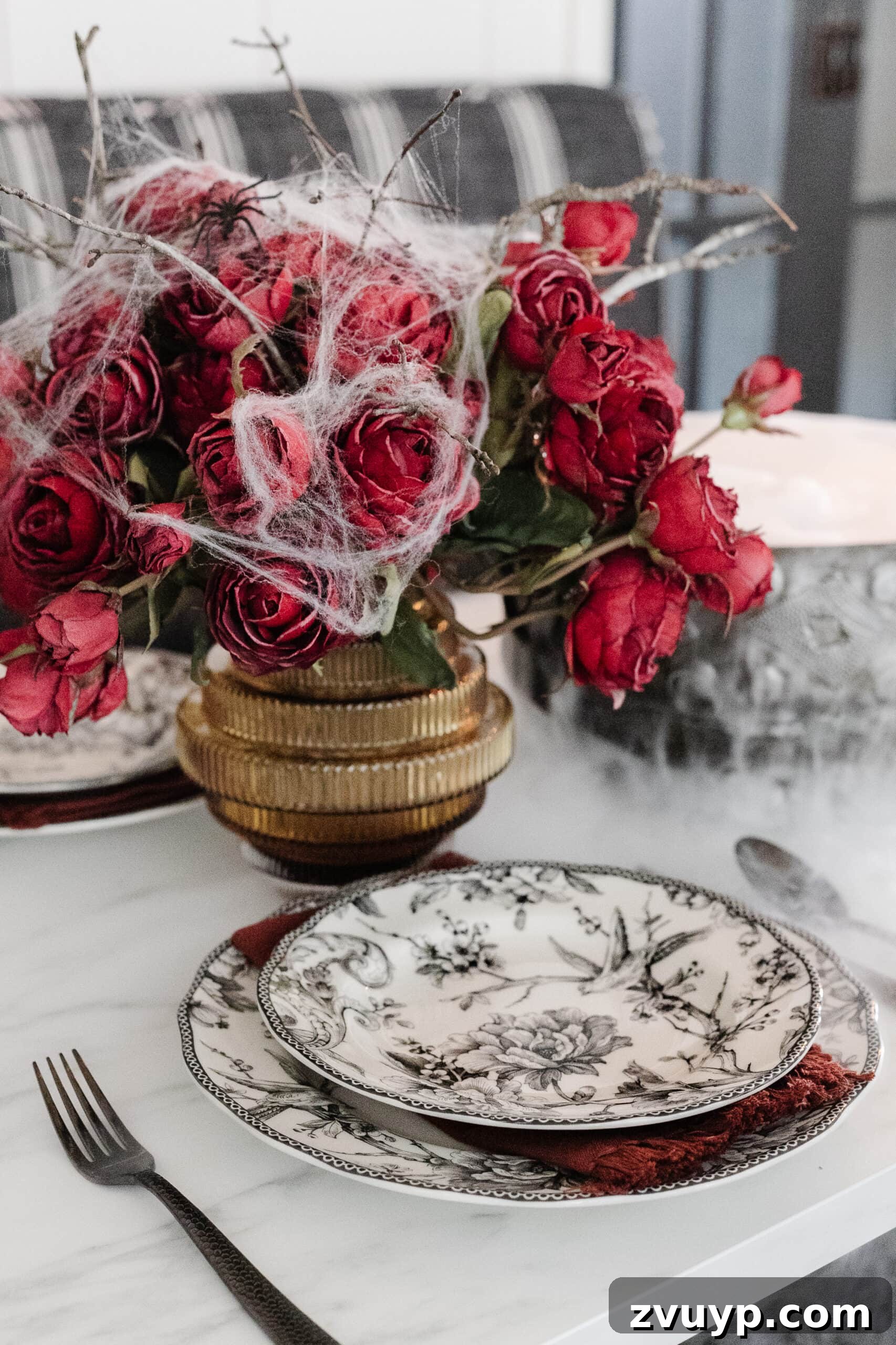 Killer Tablescapes for Your Halloween Murder Mystery 8 black toile dinnerware and fluted vase of red roses with spider webs