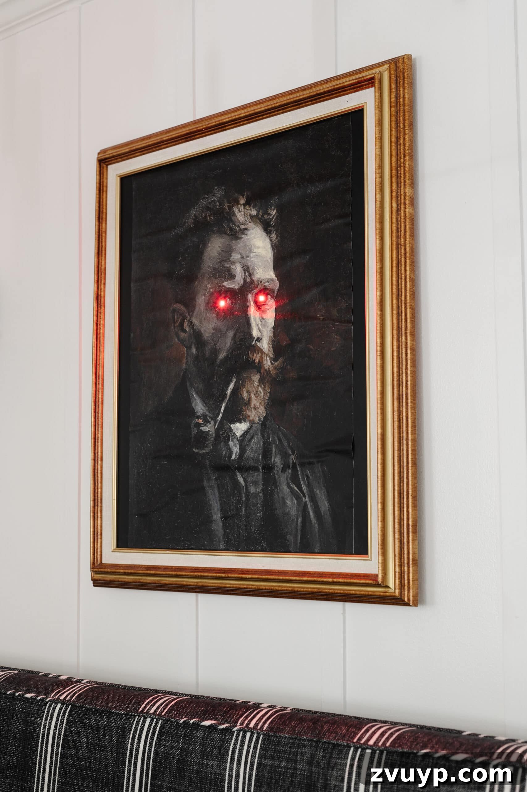 Creepy Halloween art with glowing eyes in a gold picture frame for DIY Halloween wall decor.