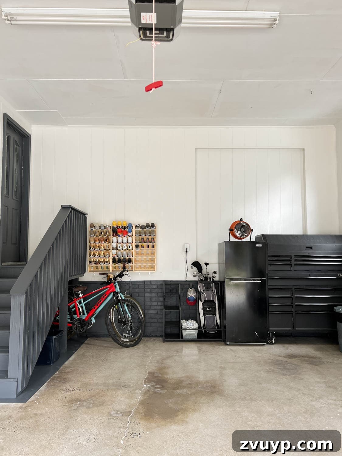 Reclaim Your Garage Space with Smart Storage 2 garage after with white walls and black trim and repurposed concrete floor