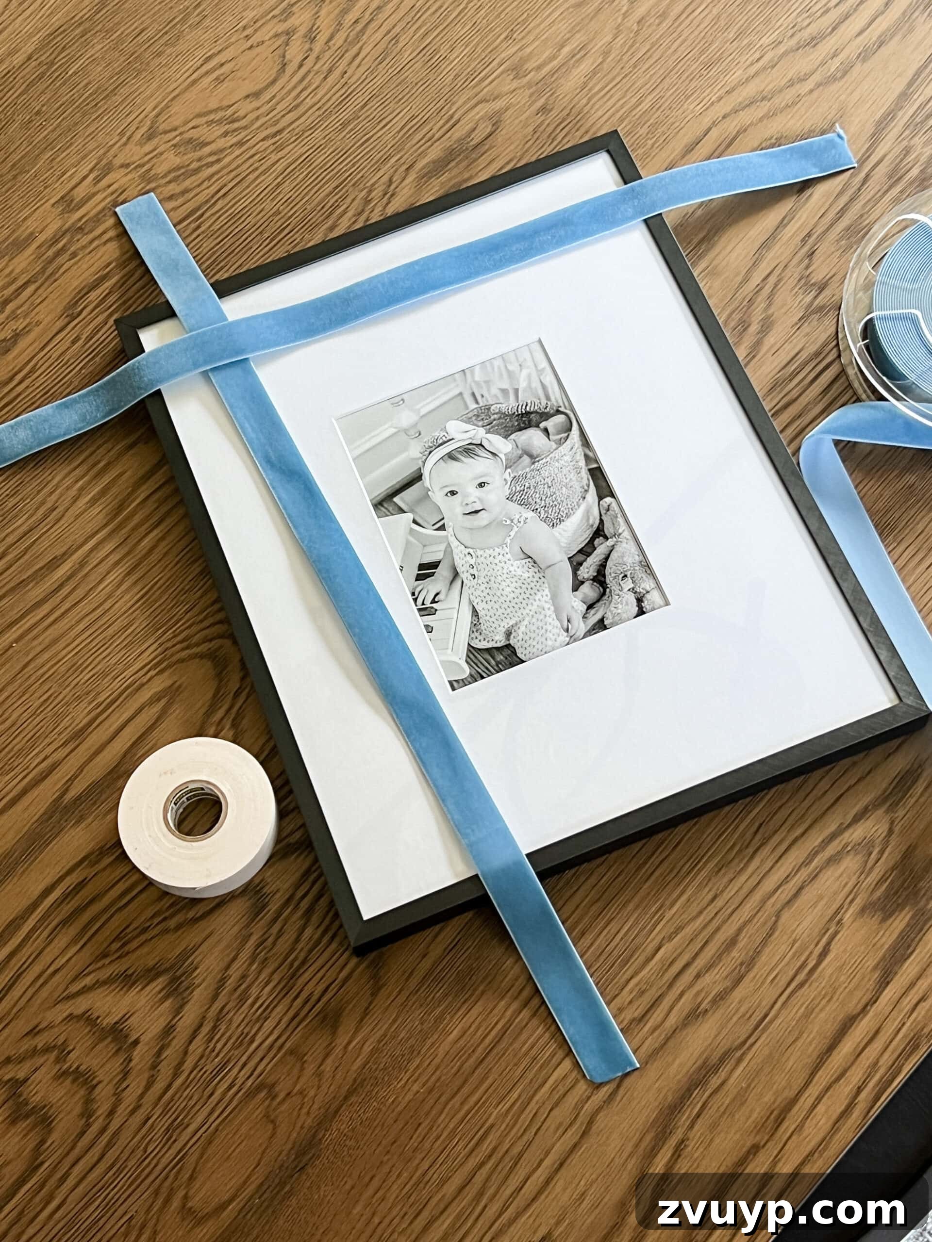 Easy 5-Minute Christmas Bow Craft 4 Demonstration of cutting ribbon to the appropriate length for wrapping around a picture frame for holiday decoration.