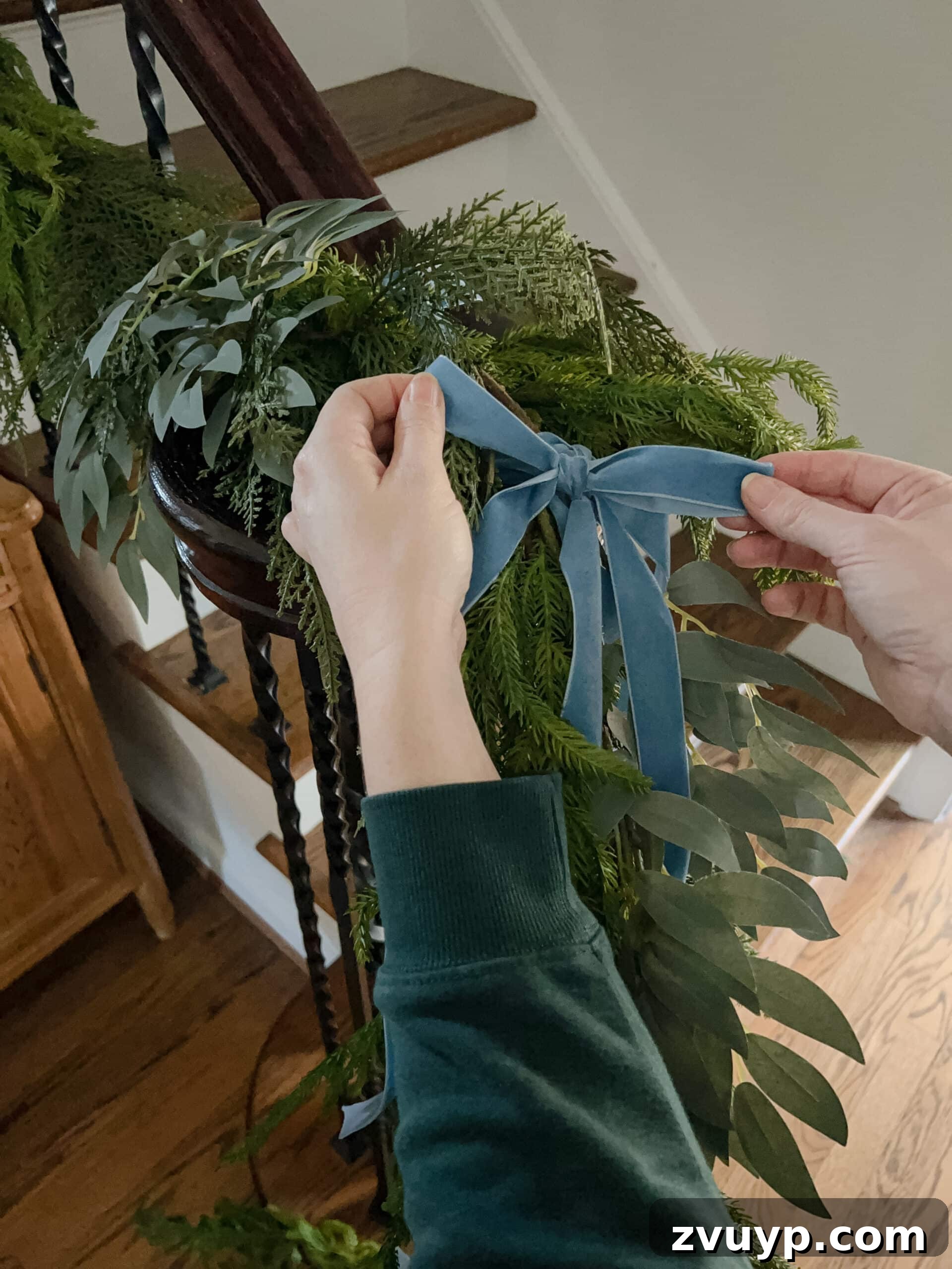 Deck the Halls Staircase and Entryway Christmas Garland Decor 12 adding bows to staircase garland