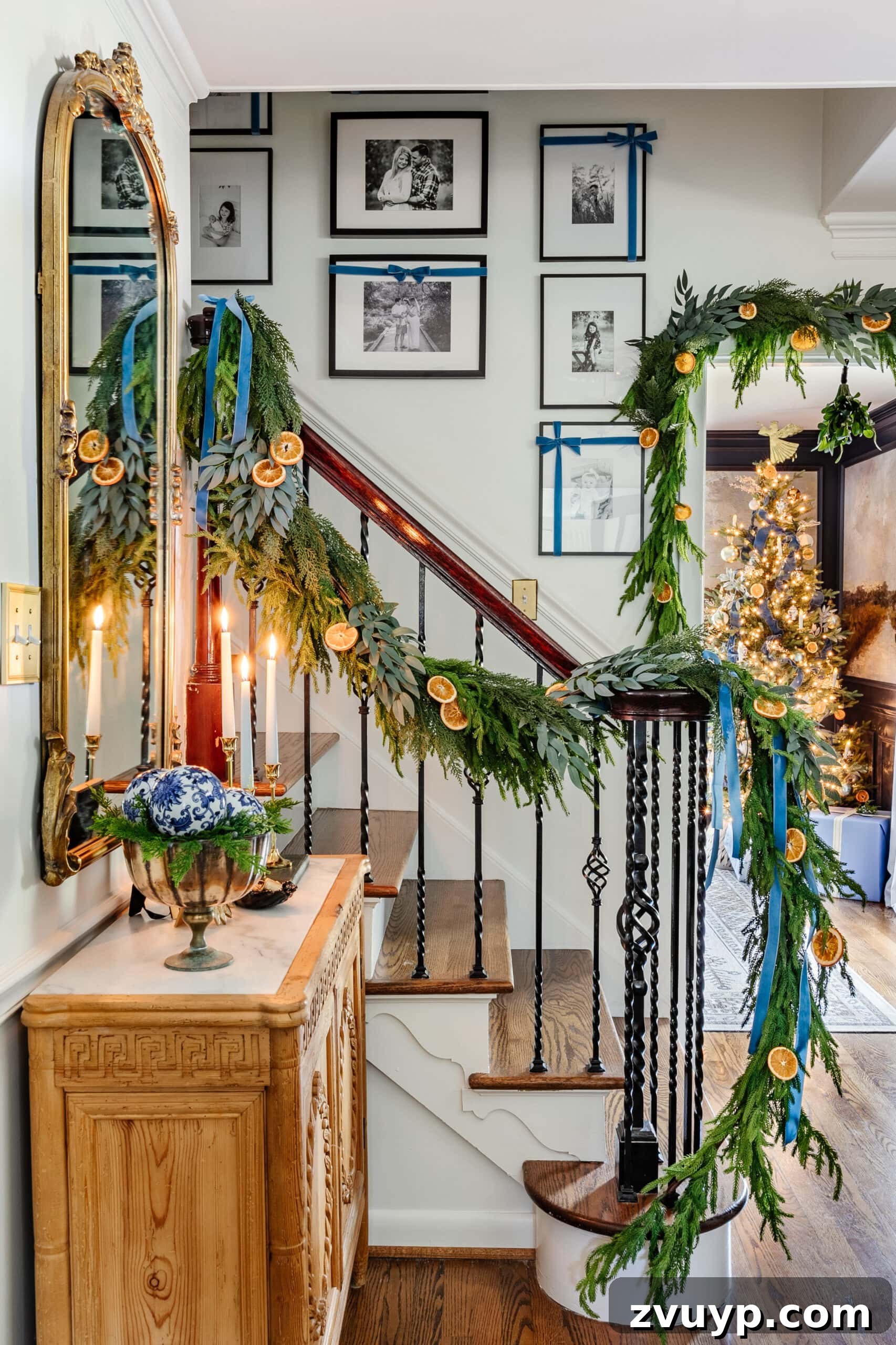 Deck the Halls Staircase and Entryway Christmas Garland Decor 14 blue and white entryway Christmas decor with staircase garland of greenery, dried oranges, and blue ribbon