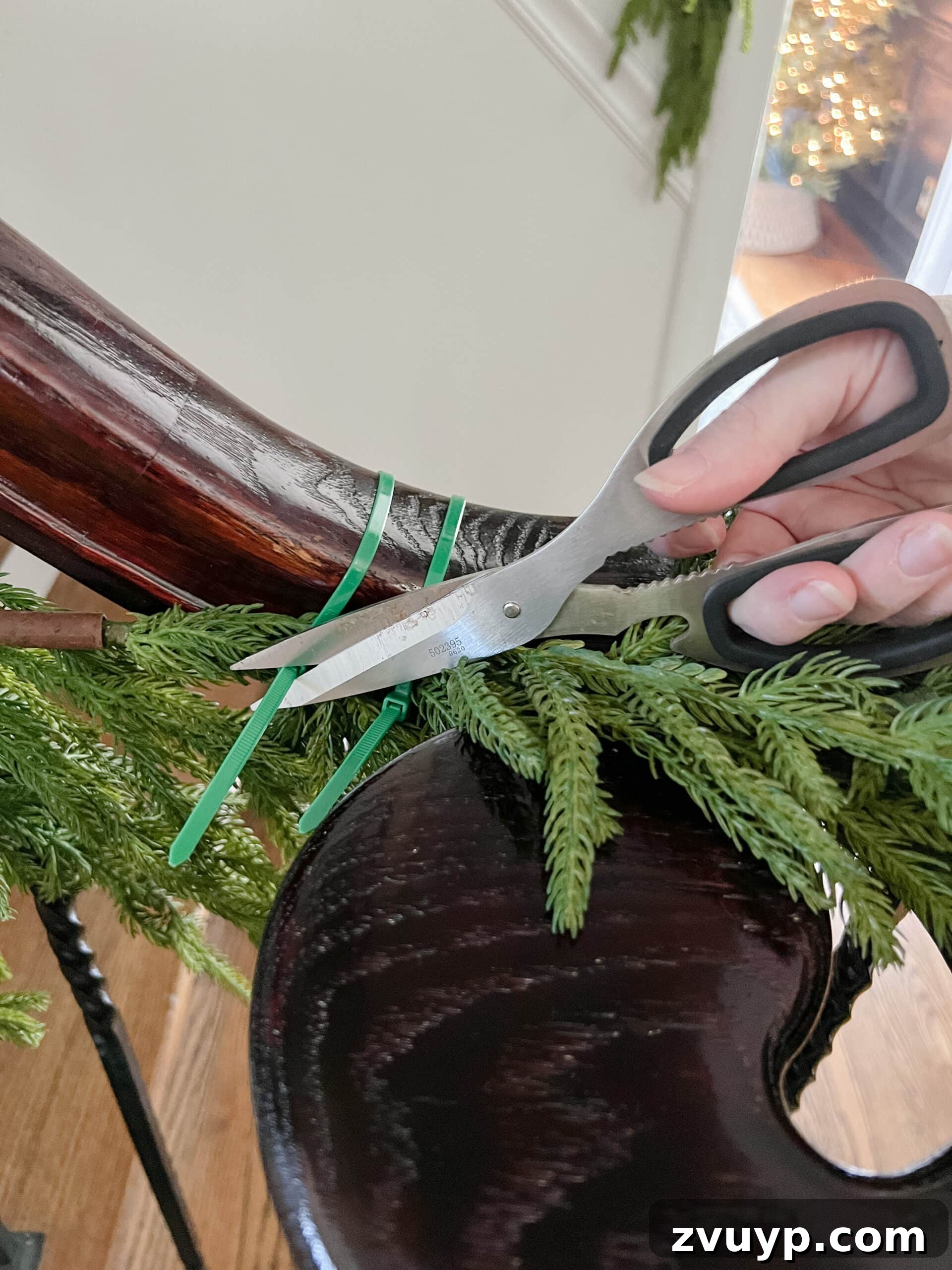 Deck the Halls Staircase and Entryway Christmas Garland Decor 7 cutting zip ties with scissors