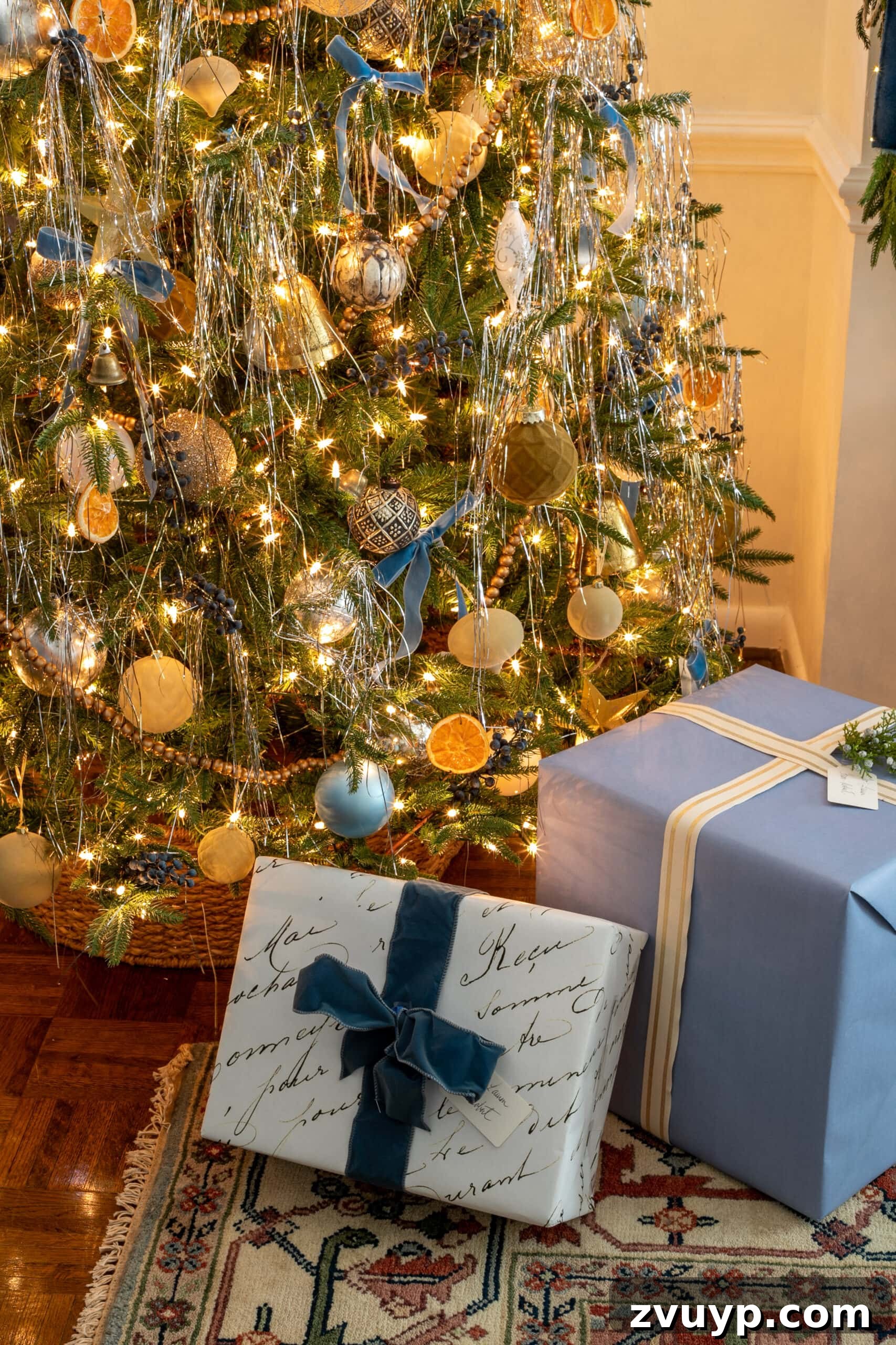 Festive Comfort: Living Room Decor for a Magical Christmas 15 A festive tinsel Christmas tree surrounded by beautifully wrapped presents in blue and white, contributing to a cohesive holiday color scheme.