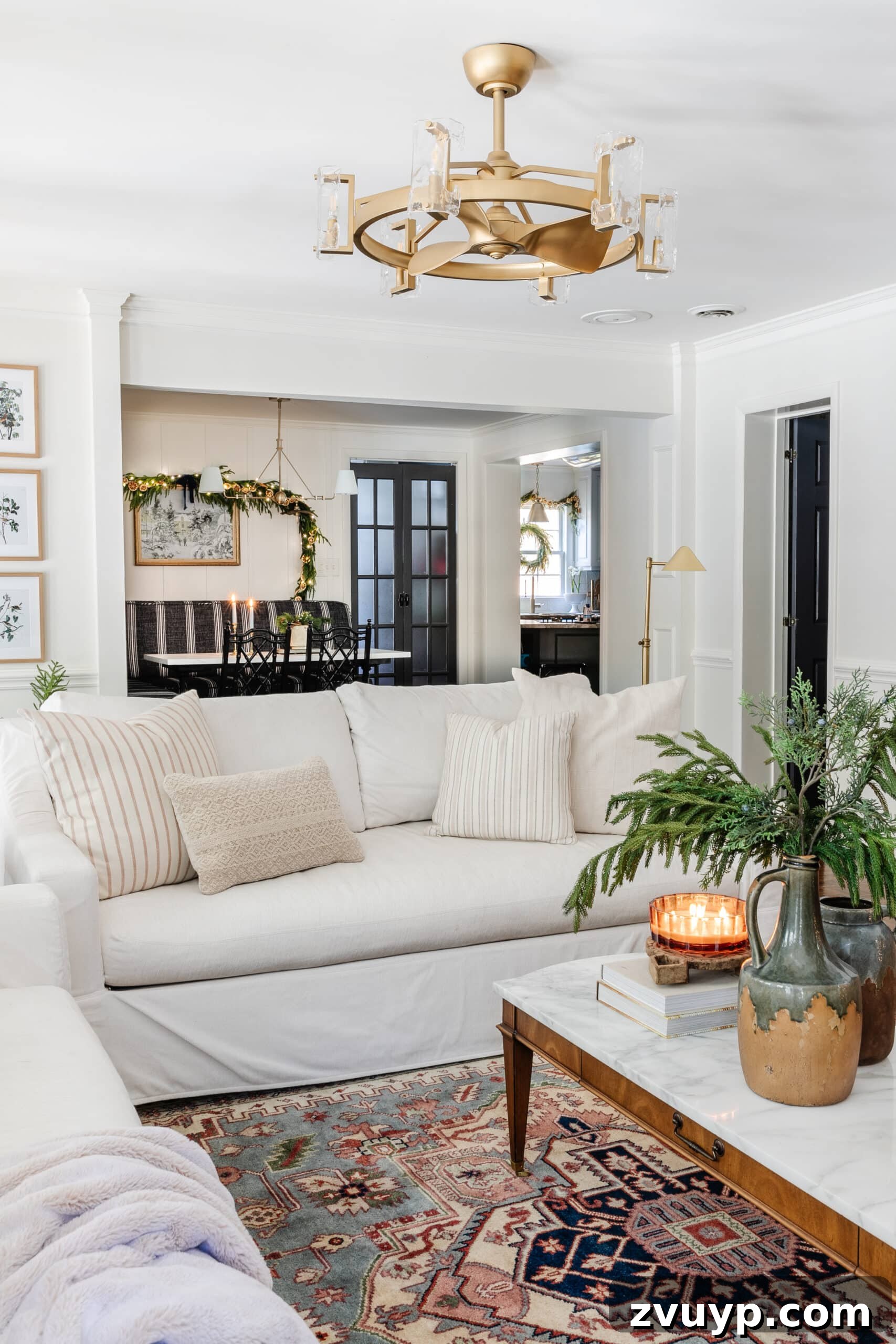 Festive Comfort: Living Room Decor for a Magical Christmas 17 A pristine white sofa adorned with an array of neutral pillows, complemented by a vintage rug and tasteful Christmas decor on the coffee table, creating an inviting and harmonious living space.