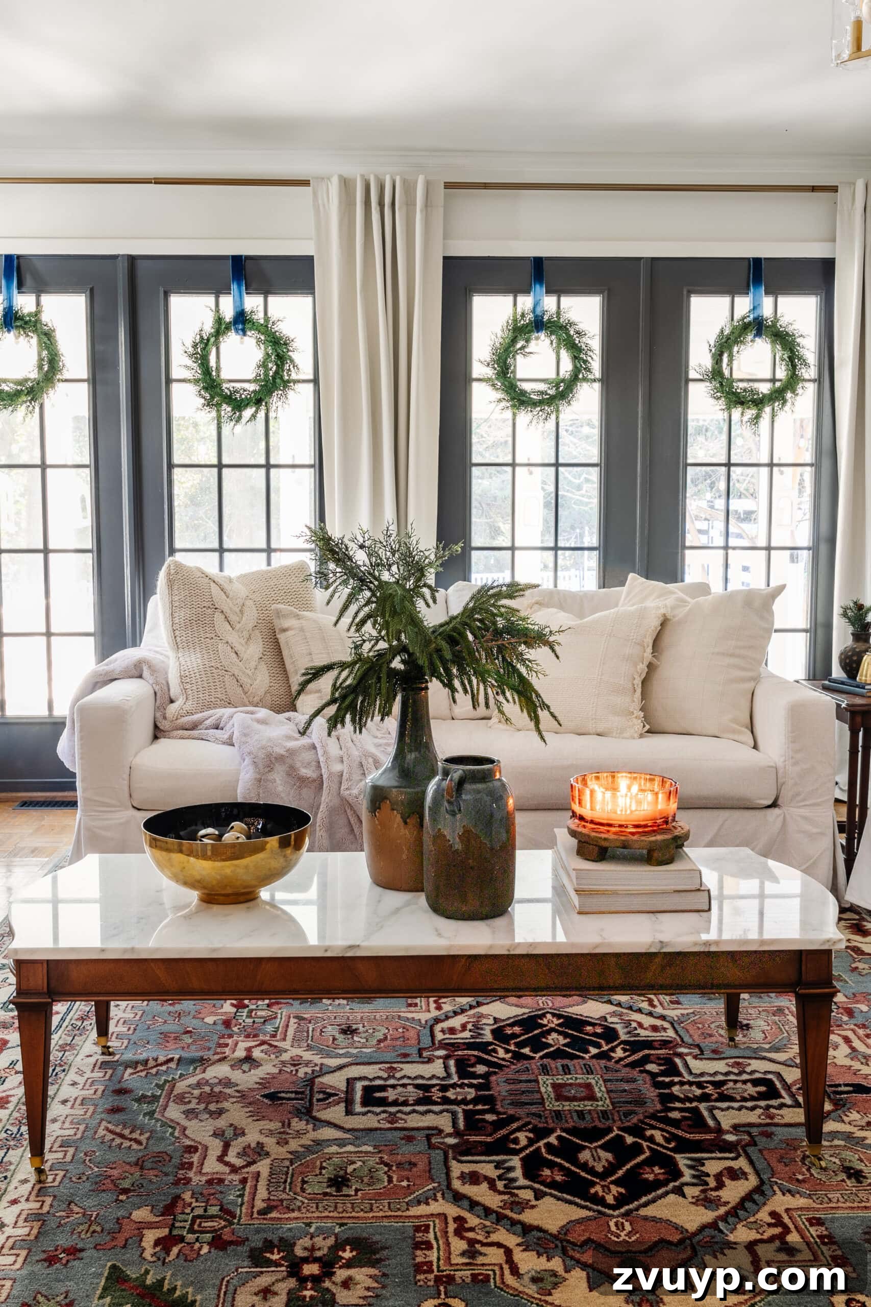 Festive Comfort: Living Room Decor for a Magical Christmas 10 A marble-top coffee table styled with a vase of Christmas greenery, a bowl of jingle bells, and a candle, embodying elegant holiday decor.