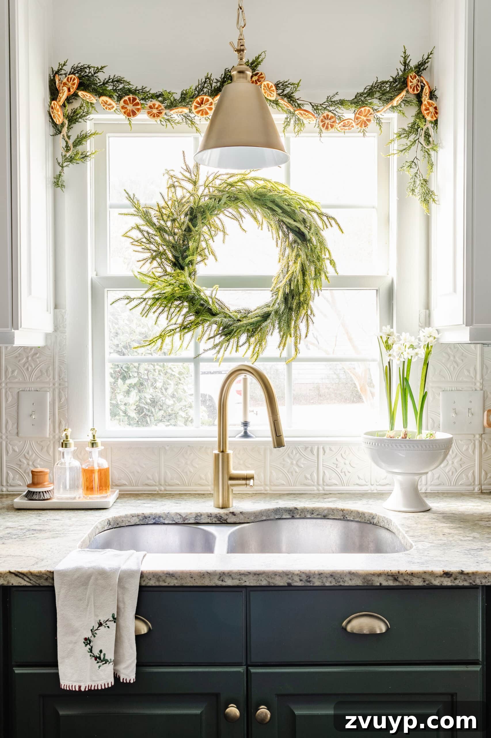 9 Quick Christmas Kitchen Transformations 5 wreath and garland with dried oranges on a kitchen window for Christmas