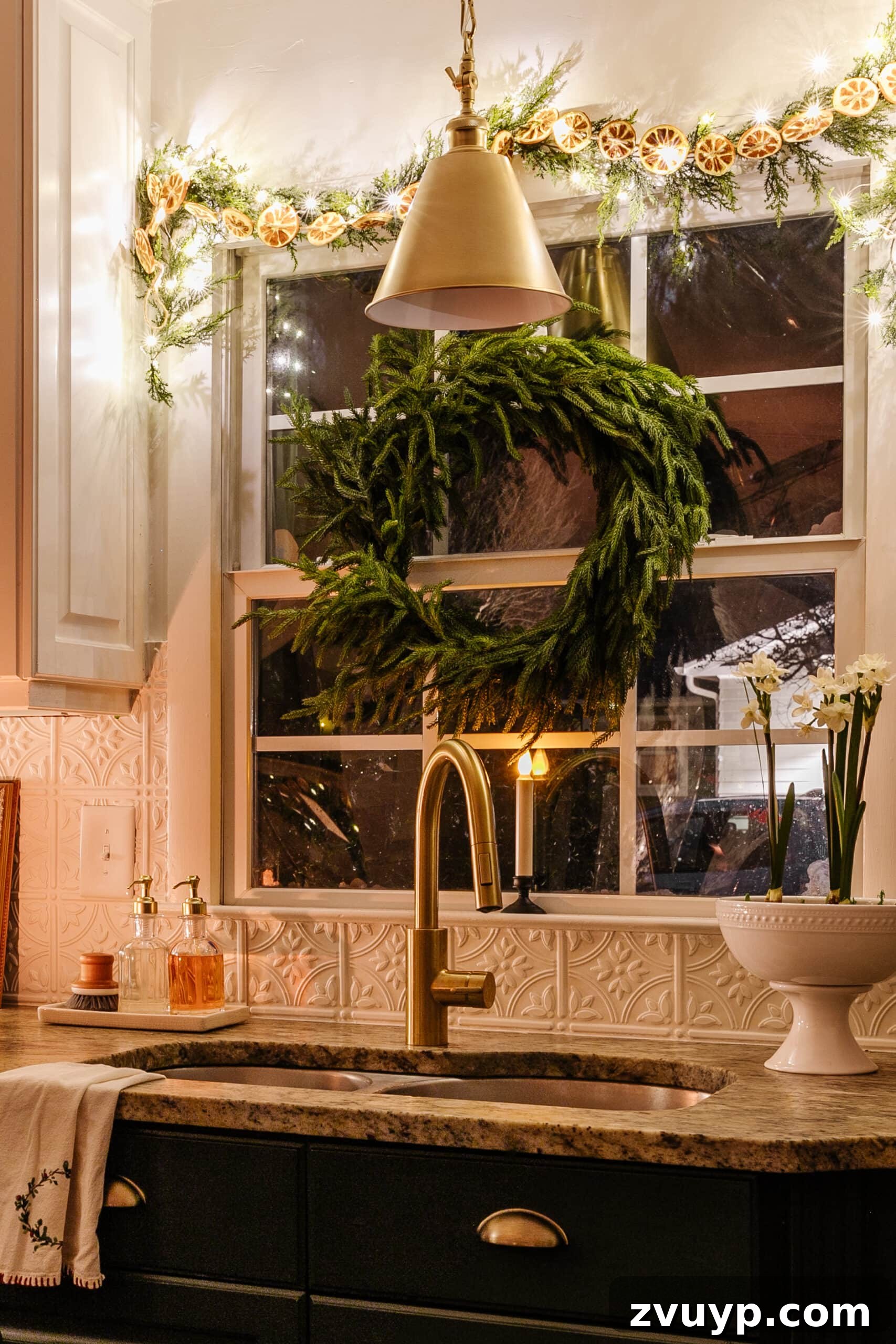 9 Quick Christmas Kitchen Transformations 6 kitchen sink decorated for Christmas with wreath, garland, and bowl of paperwhites for holiday cheer