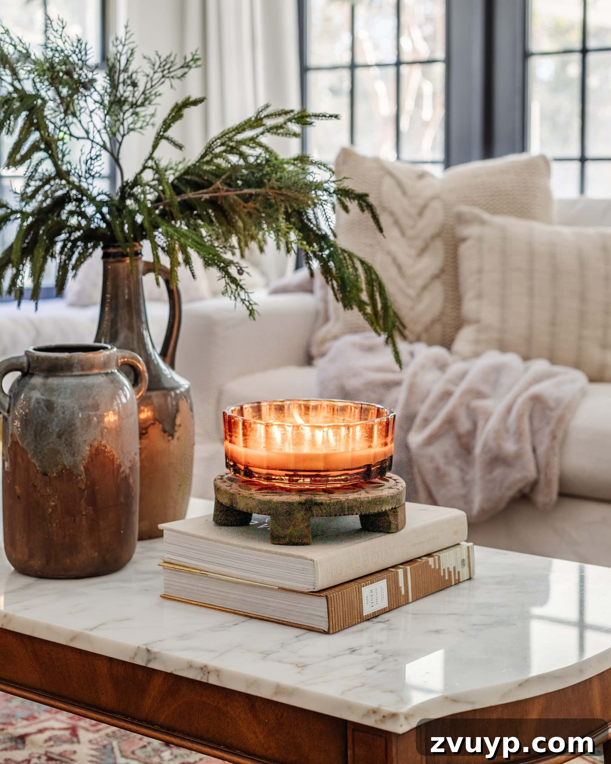 Warm Up Your Home 16 Cozy January Decor Essentials 4 candle, books, and vase with winter branches on a coffee table for January decor