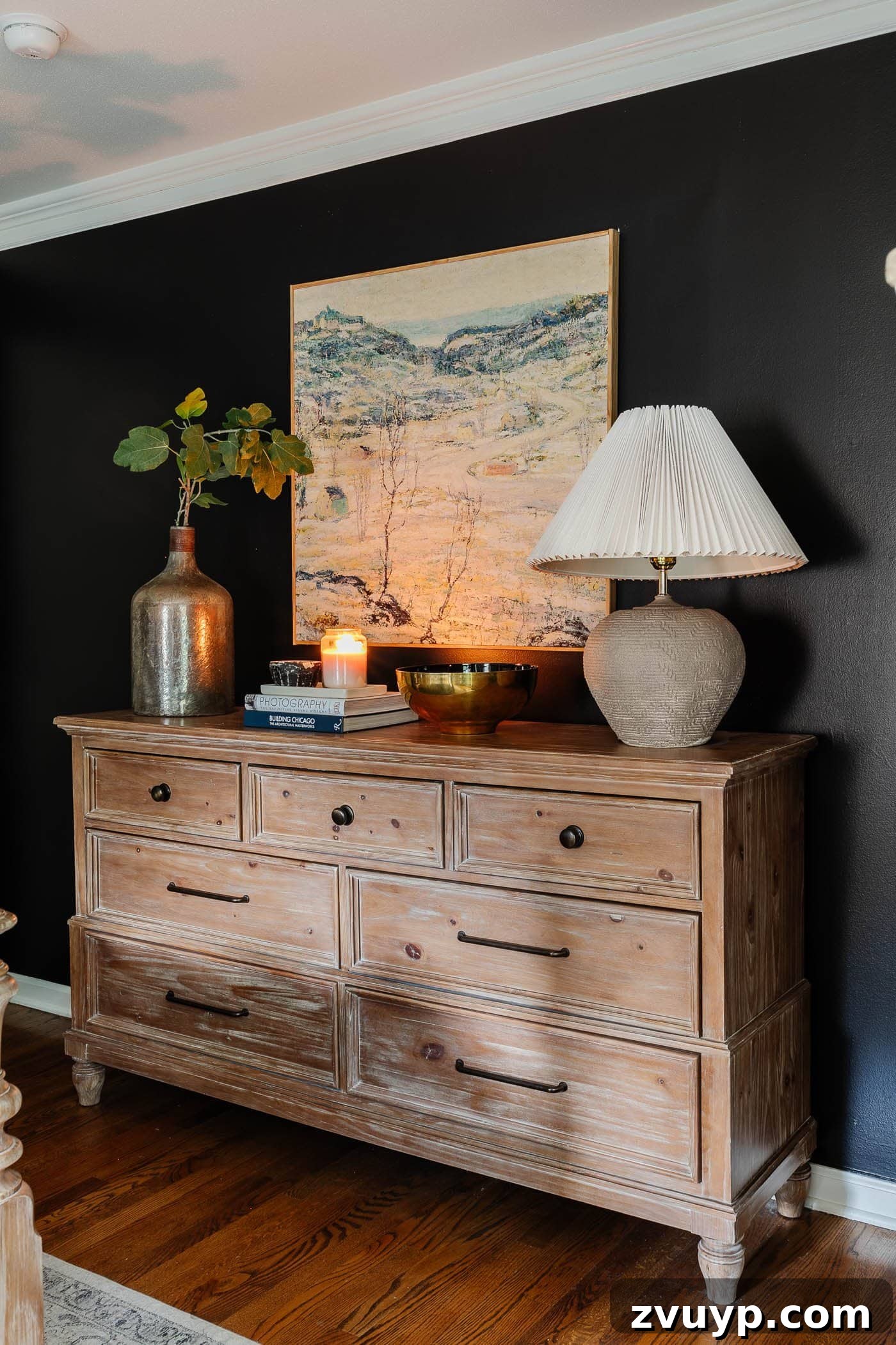 Winter Warm-Up: Easy Decor for a Cozy Retreat 15 Cozy winter bedroom decor on a dresser with a lamp, art, candle, and a vase of greenery