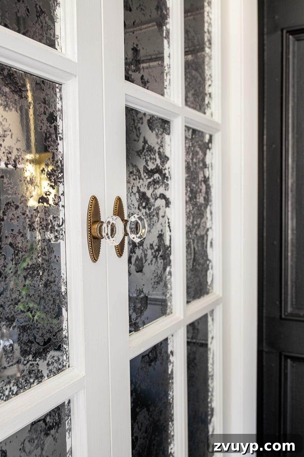 Parisian Chic on a Shoestring Budget 12 Close-up of antique mirror French door bifold doors, achieved affordably using window film, showcasing the elegant reflective quality for a Parisian aesthetic.