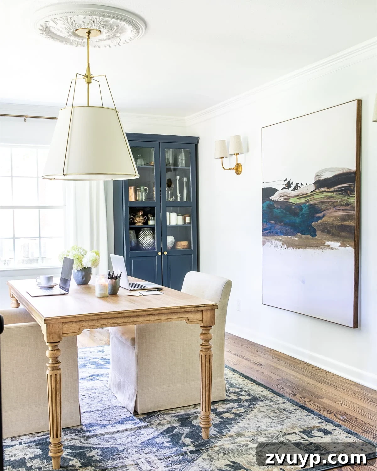 Parisian Chic on a Shoestring Budget 15 A minimalist home office with clean white walls, featuring a striking large abstract art piece that adds a modern yet elegant touch, reflecting Parisian chic.