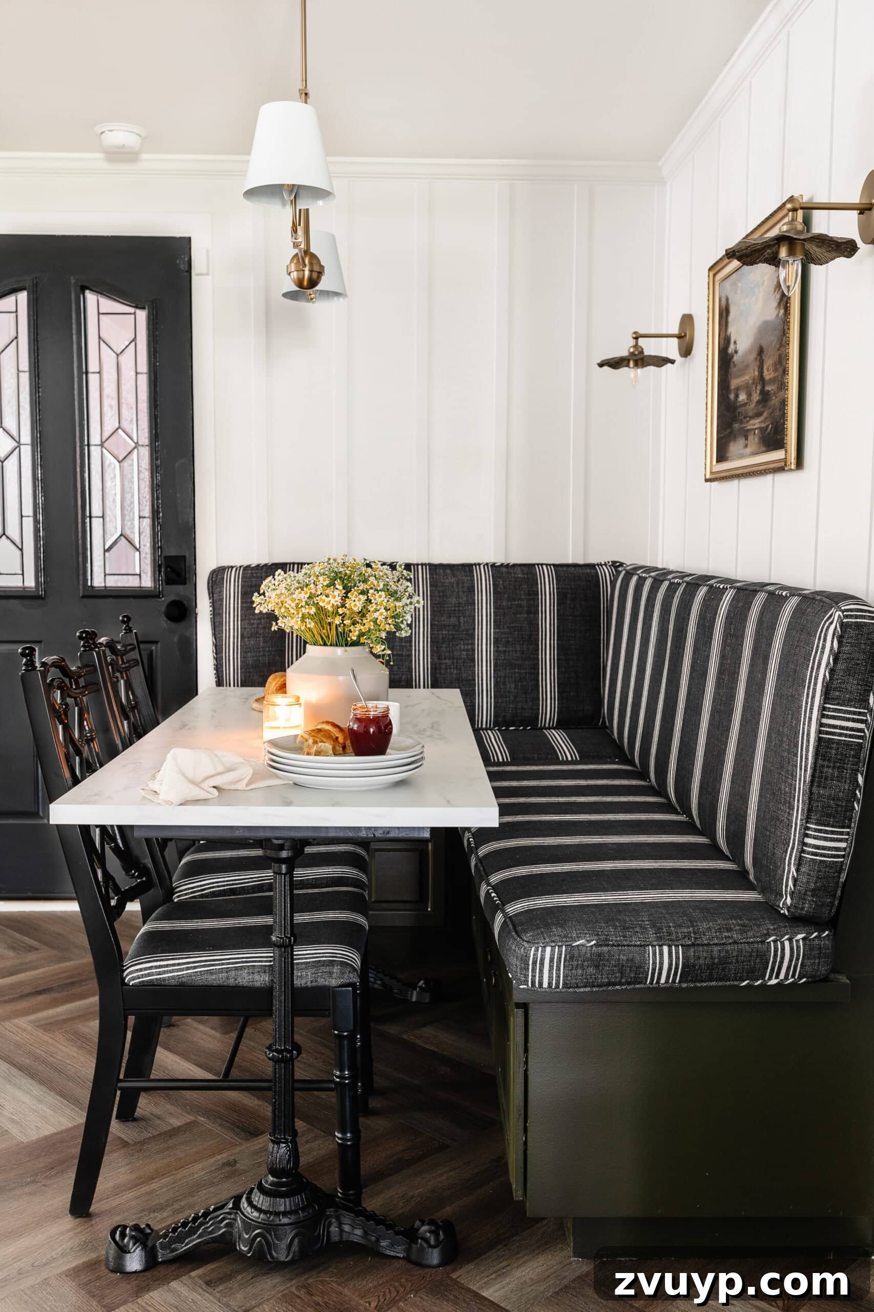 Parisian Chic on a Shoestring Budget 4 Charming breakfast nook featuring a DIY French bistro table with a faux marble top and a comfortable banquette, set against a classic herringbone floor.