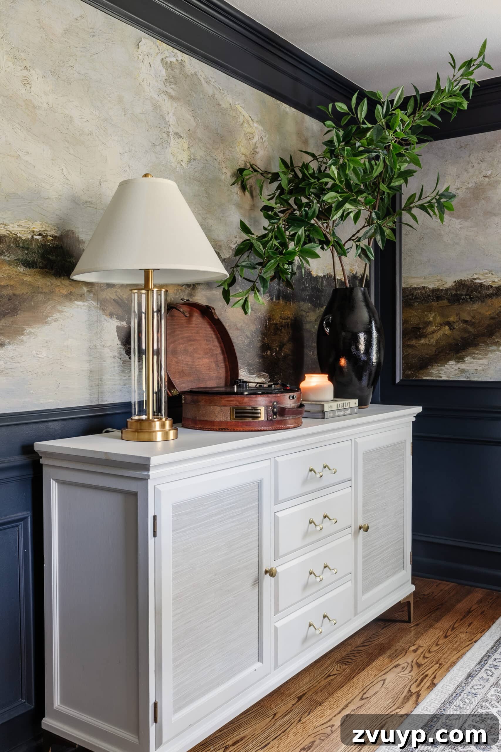 Parisian Chic on a Shoestring Budget 9 A sophisticated dining room featuring a white buffet, deep navy walls, and an impressive scenic mural wallpaper, creating a luxurious and artistic Parisian ambiance.