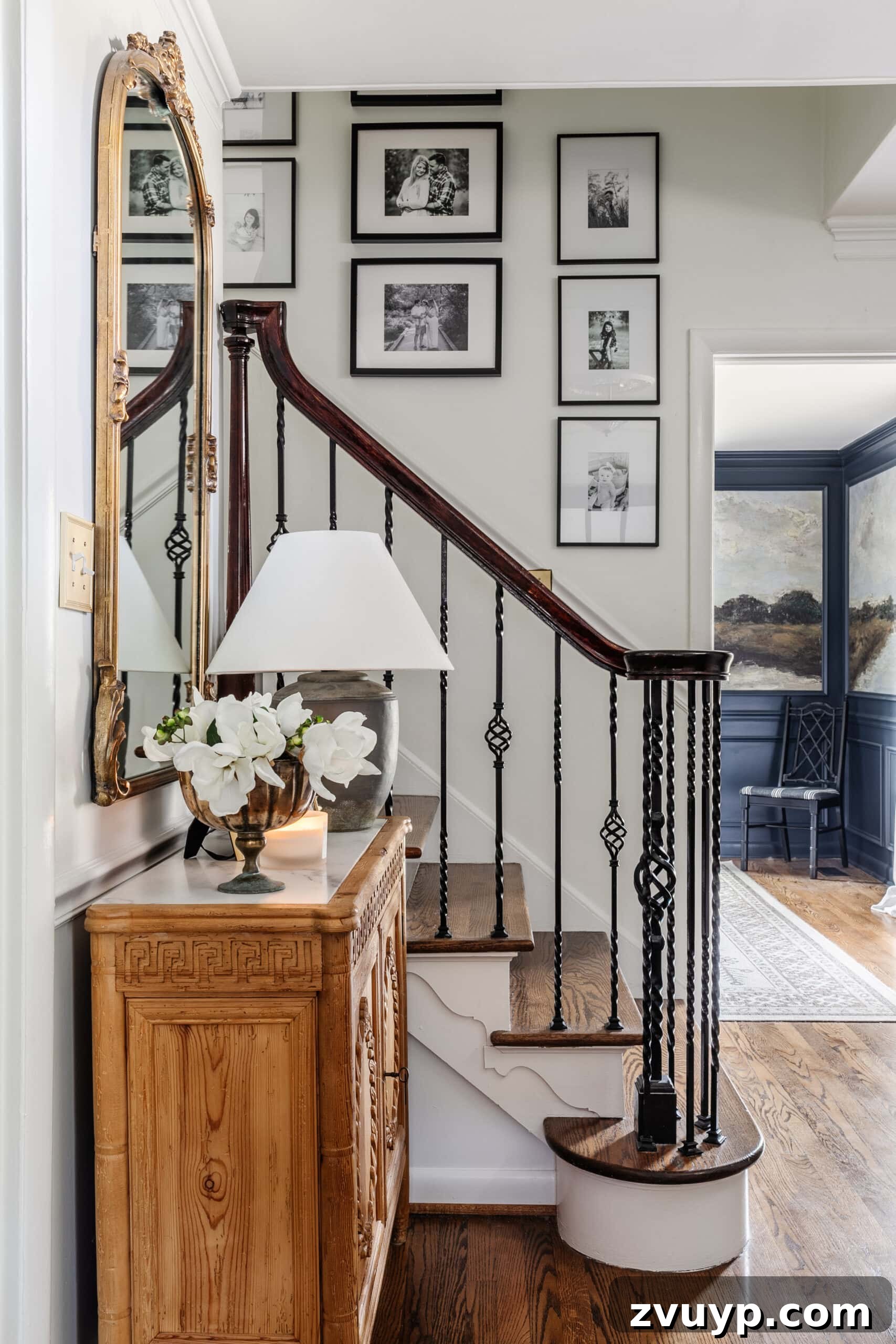 Elevate Your Foyer: 9 Dramatic Black Stair Railing Designs 2 entryway staircase with black and white gallery wall