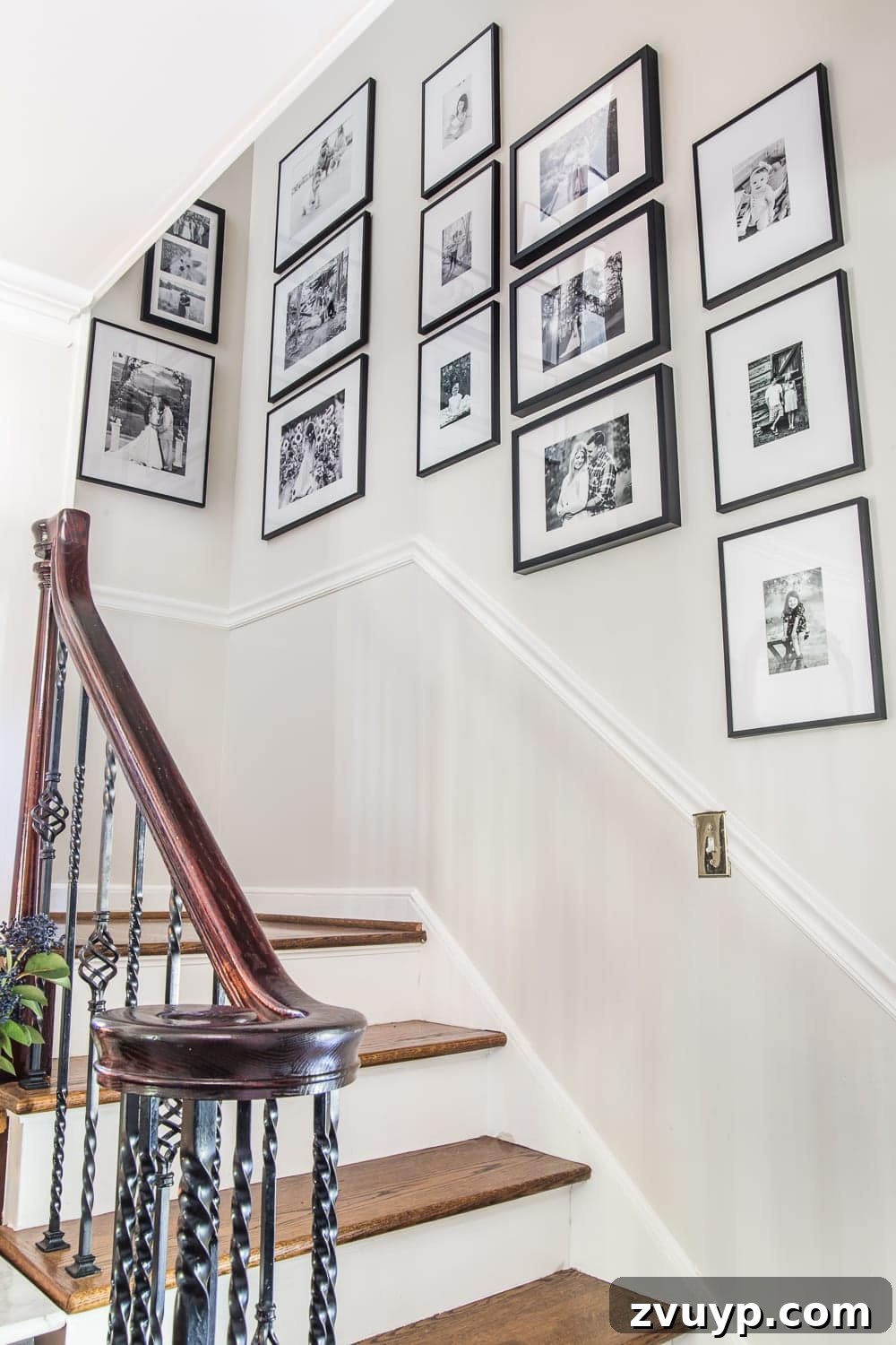 Elevate Your Foyer: 9 Dramatic Black Stair Railing Designs 4 black and white staircase gallery wall