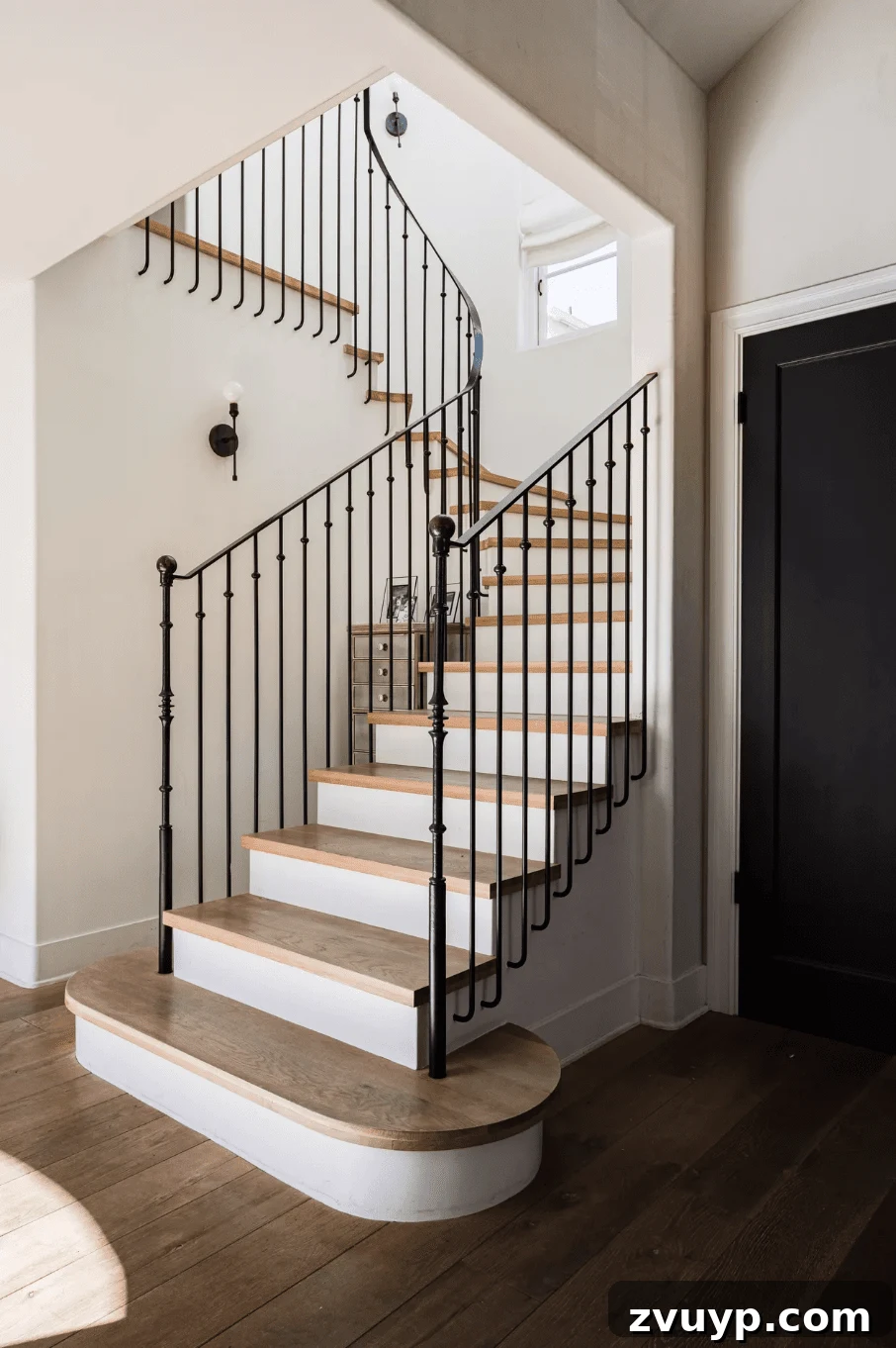 Elevate Your Foyer: 9 Dramatic Black Stair Railing Designs 7 wrought iron black stair railing with white risers and wood treads