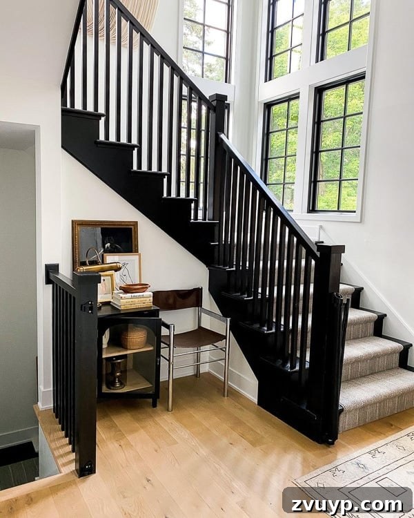 Elevate Your Foyer: 9 Dramatic Black Stair Railing Designs 9 black painted staircase with neutral striped rug