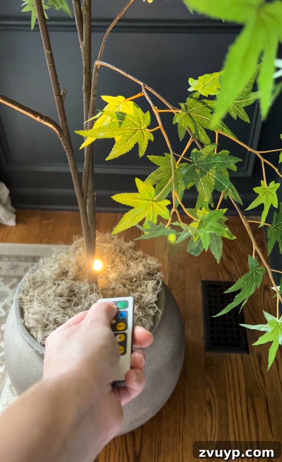 Realistic Artificial Trees: Expert Tricks for Indoor Authenticity 8 adding an uplight to a fake tree with a remote