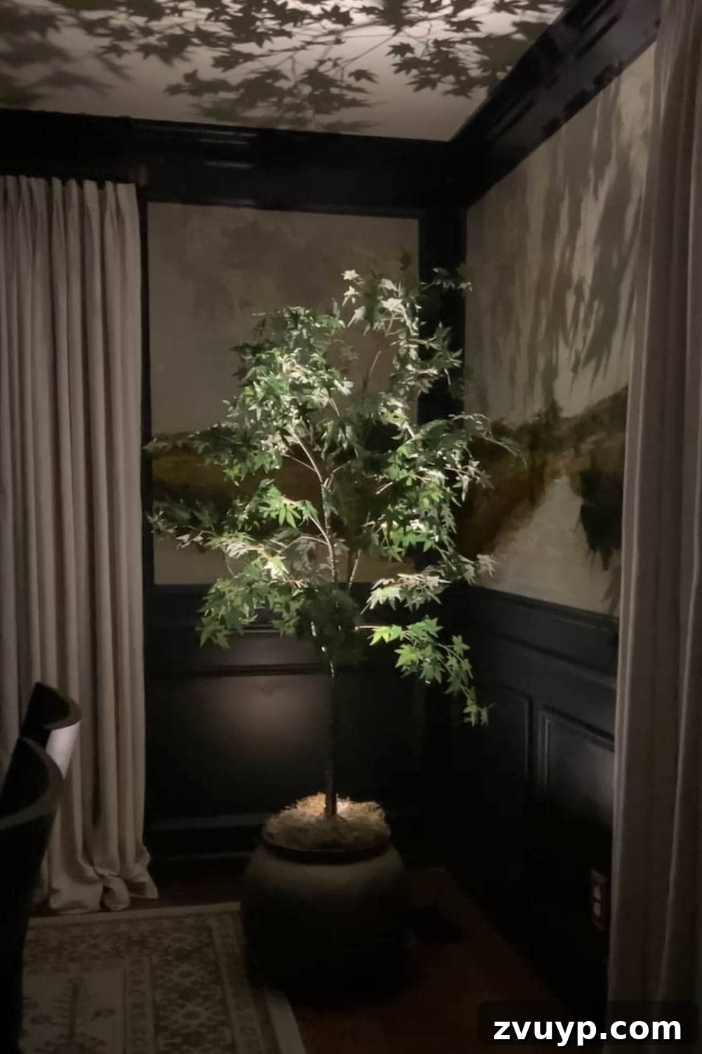Realistic Artificial Trees: Expert Tricks for Indoor Authenticity 9 spotlight at an artificial indoor tree at night