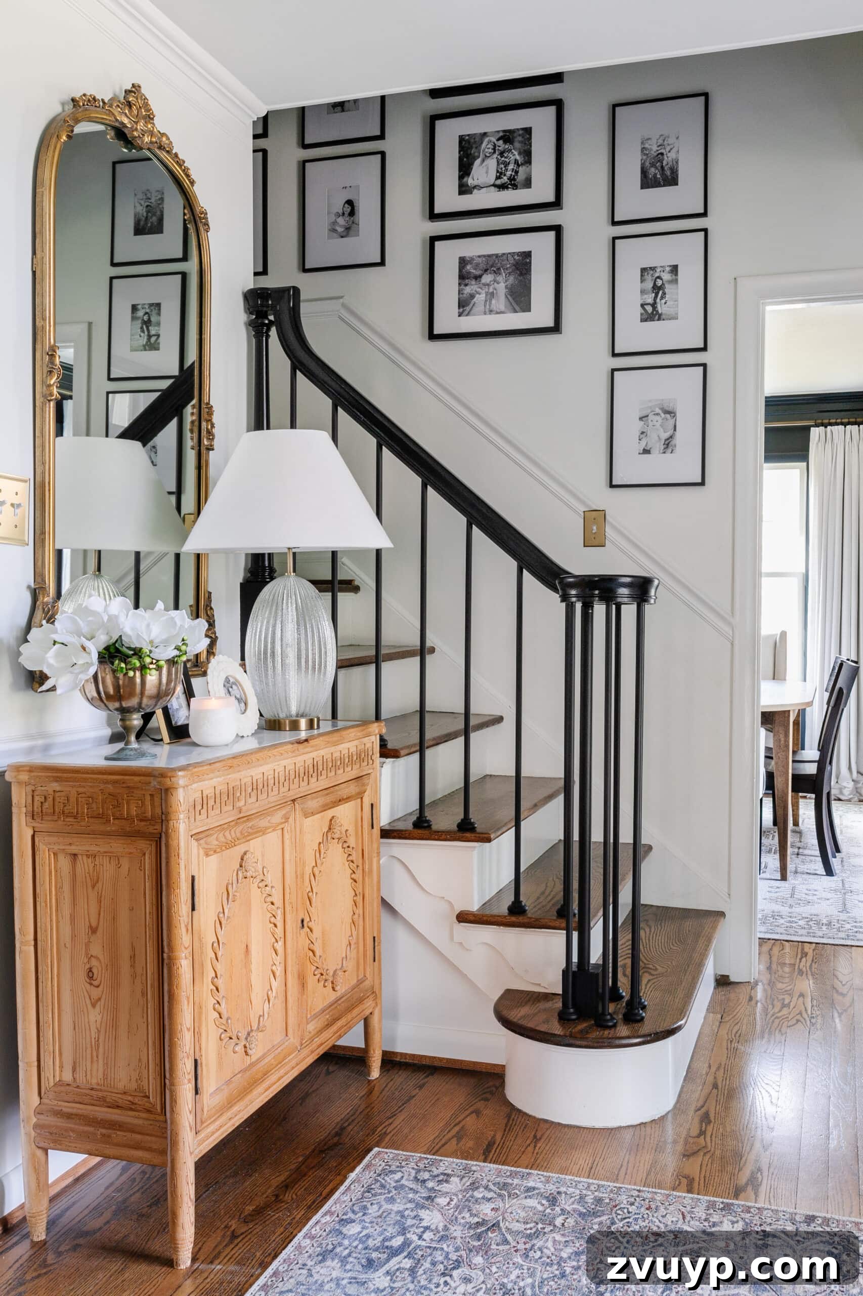DIY Stair Spindle Swap For A Modern Makeover 2 Foyer with a modern staircase featuring sleek black railing and a welcoming family gallery wall