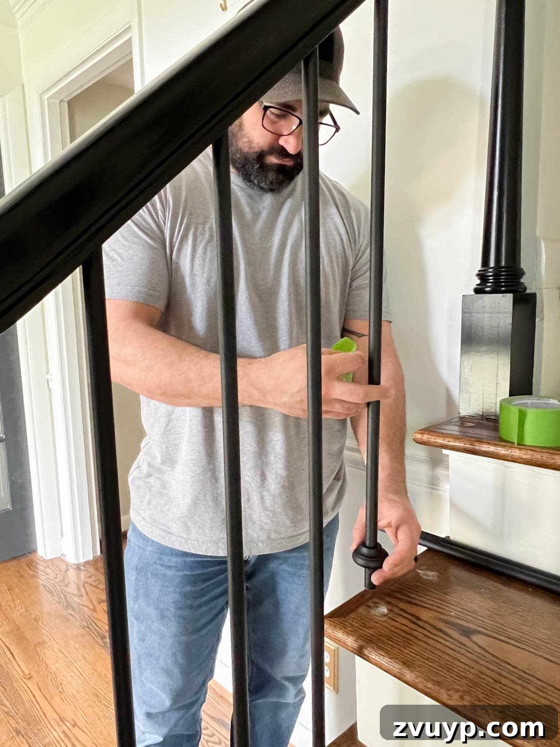 DIY Stair Spindle Swap For A Modern Makeover 26 Adding decorative shoes to iron stair balusters before final installation